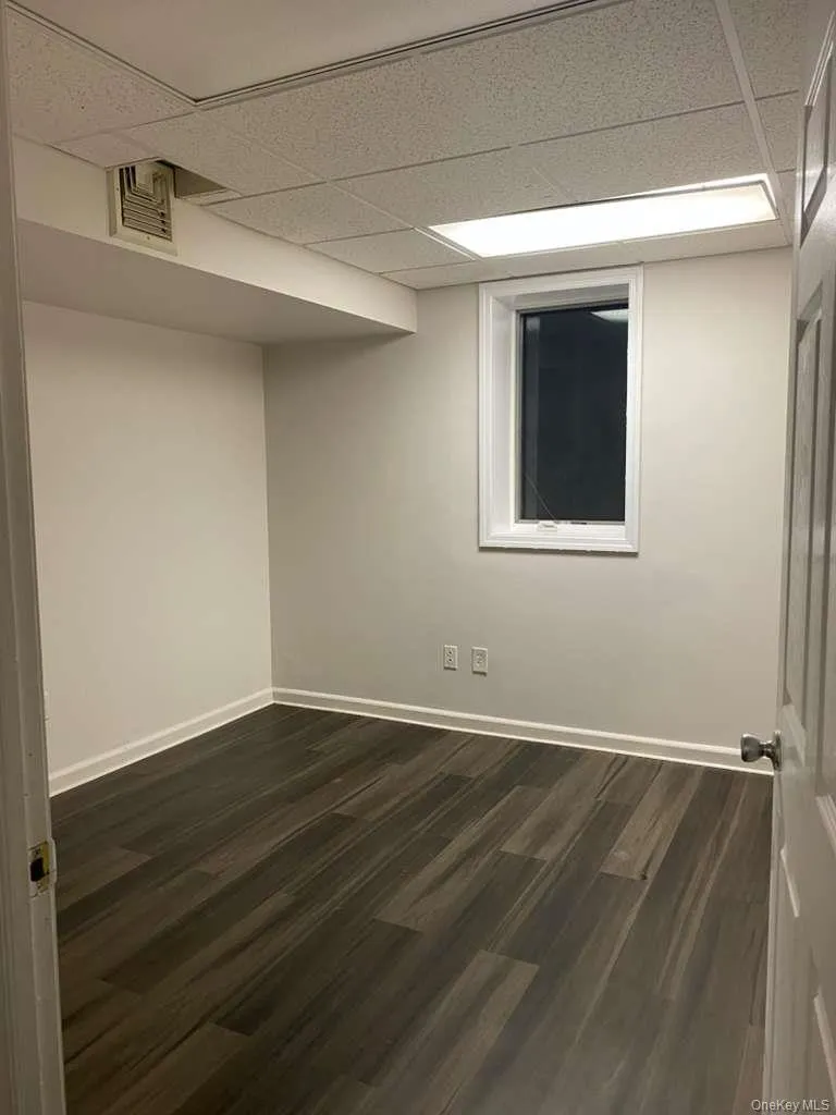 Spare room with dark wood finished floors and a drop ceiling Spare room with dark wood finished floors and a drop ceiling
