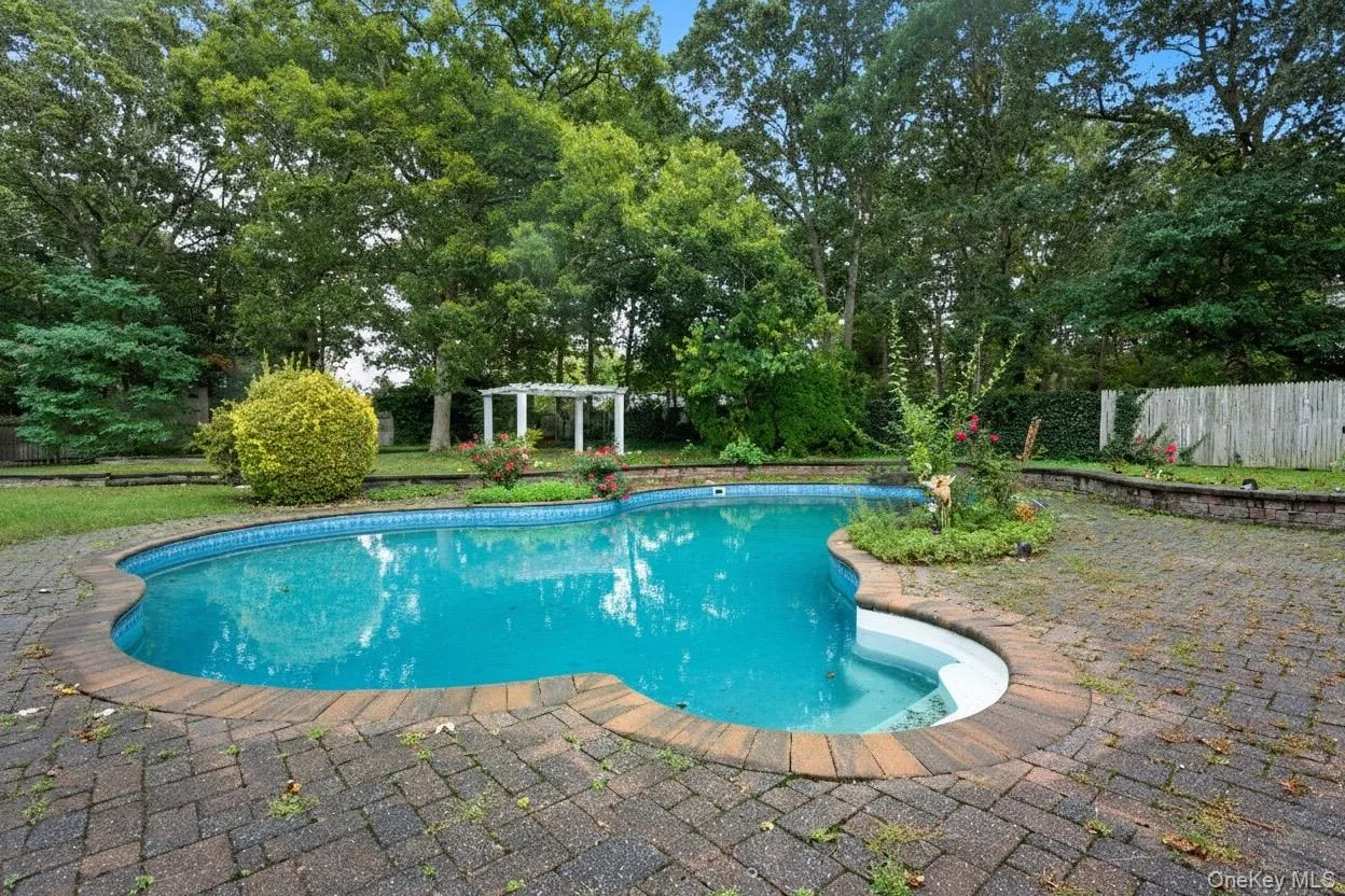 View of pool with a patio area and view of scattered trees View of pool with a patio area and view of scattered trees