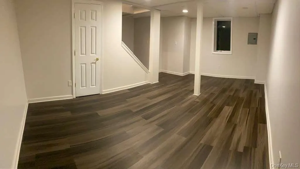 Finished basement with dark wood-style flooring and baseboards Finished basement with dark wood-style flooring and baseboards