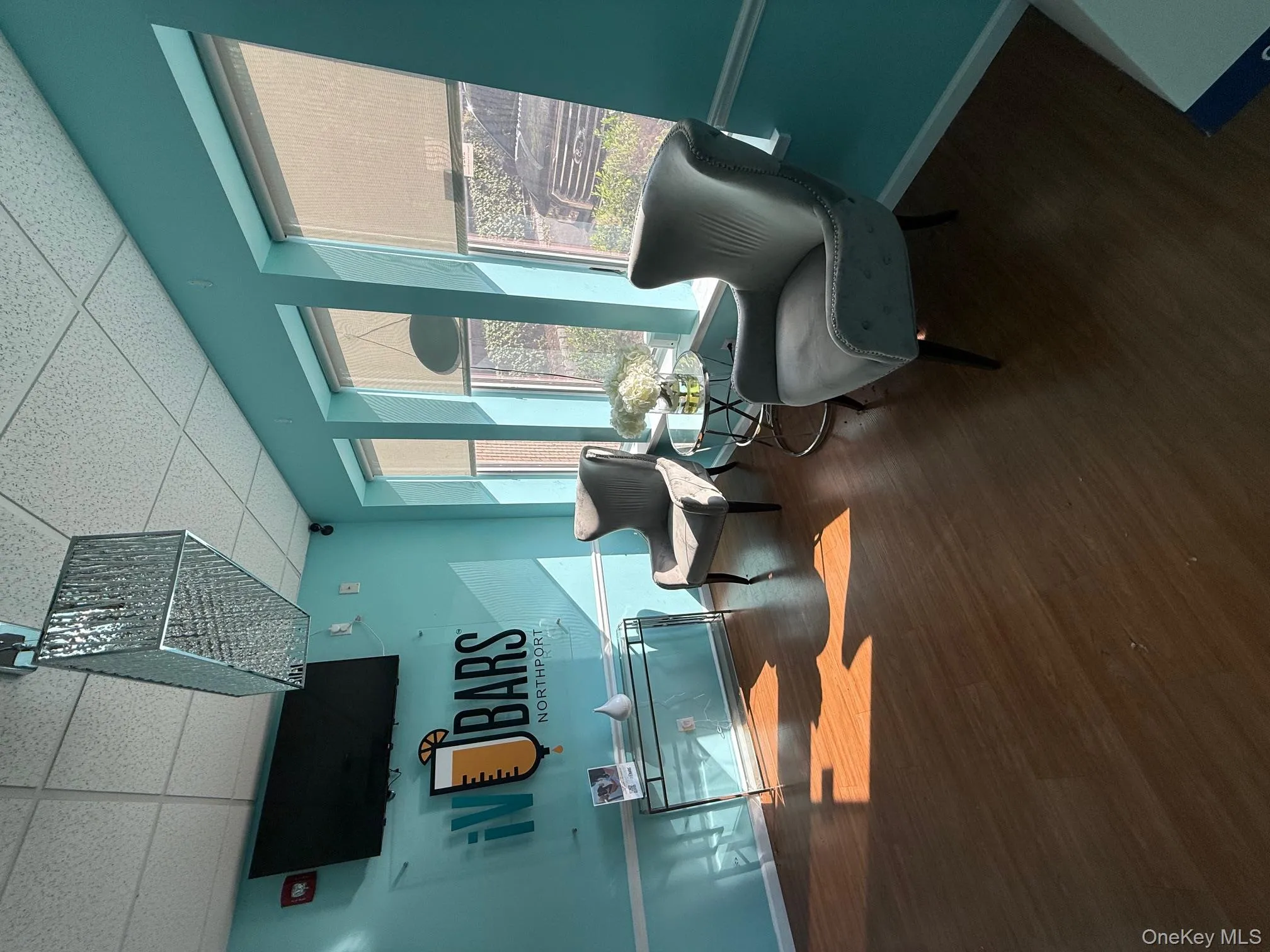 Living area with a paneled ceiling and dark wood-style flooring Living area with a paneled ceiling and dark wood-style flooring