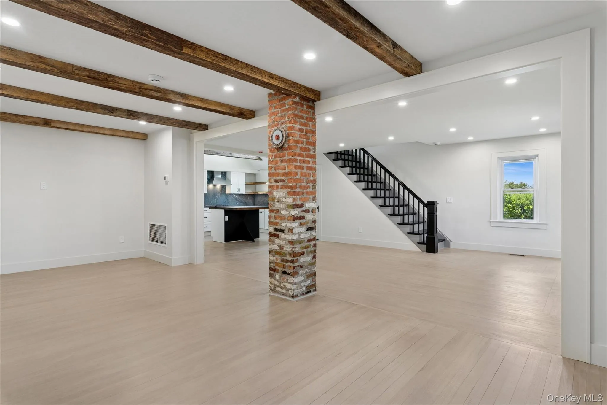 Unfurnished living room featuring light wood-style floors, recessed lighting, beamed ceiling, and stairway Unfurnished living room featuring light wood-style floors, recessed lighting, beamed ceiling, and stairway