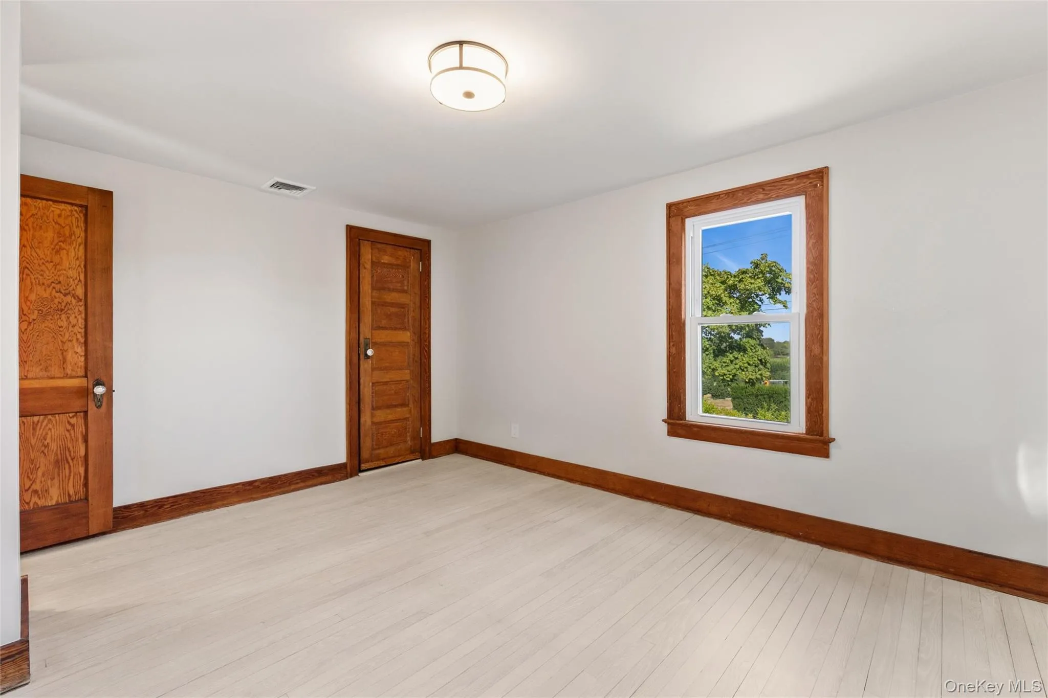 Spare room featuring baseboards and light wood-style flooring Spare room featuring baseboards and light wood-style flooring