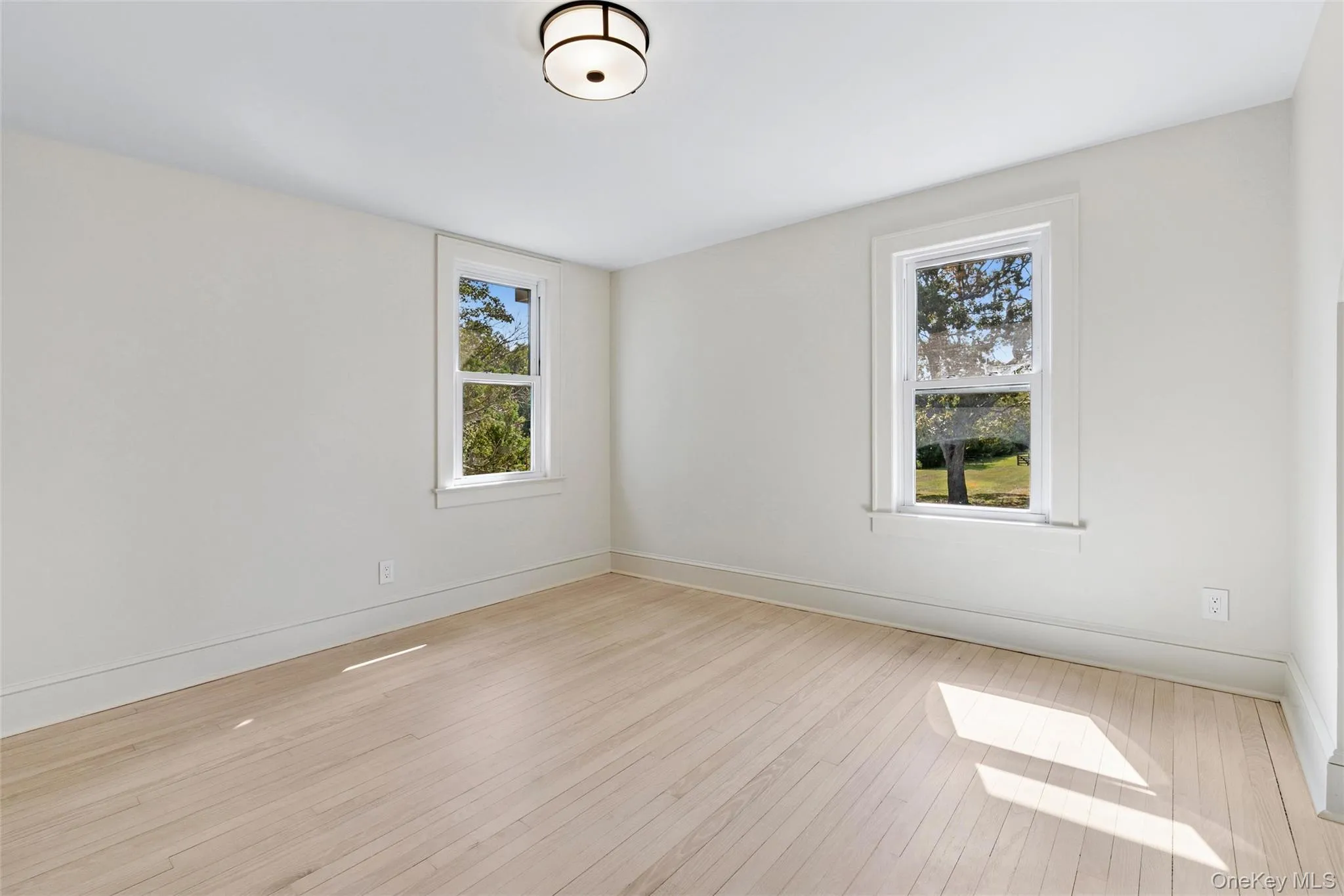 Unfurnished room with baseboards and light wood-type flooring Unfurnished room with baseboards and light wood-type flooring