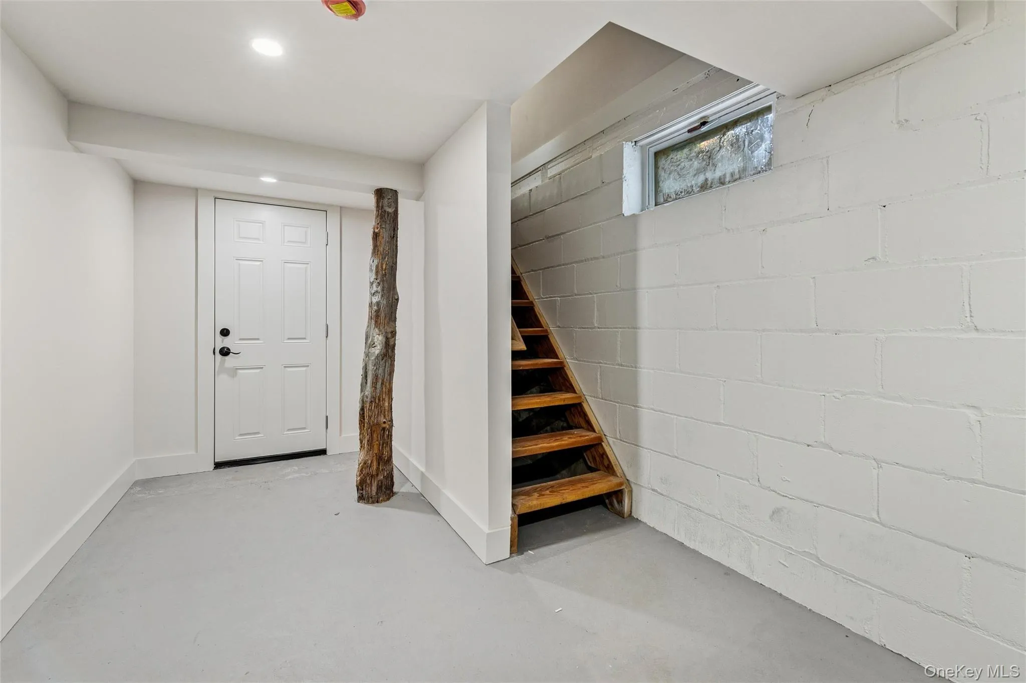 Below grade area with concrete block wall and stairs Below grade area with concrete block wall and stairs