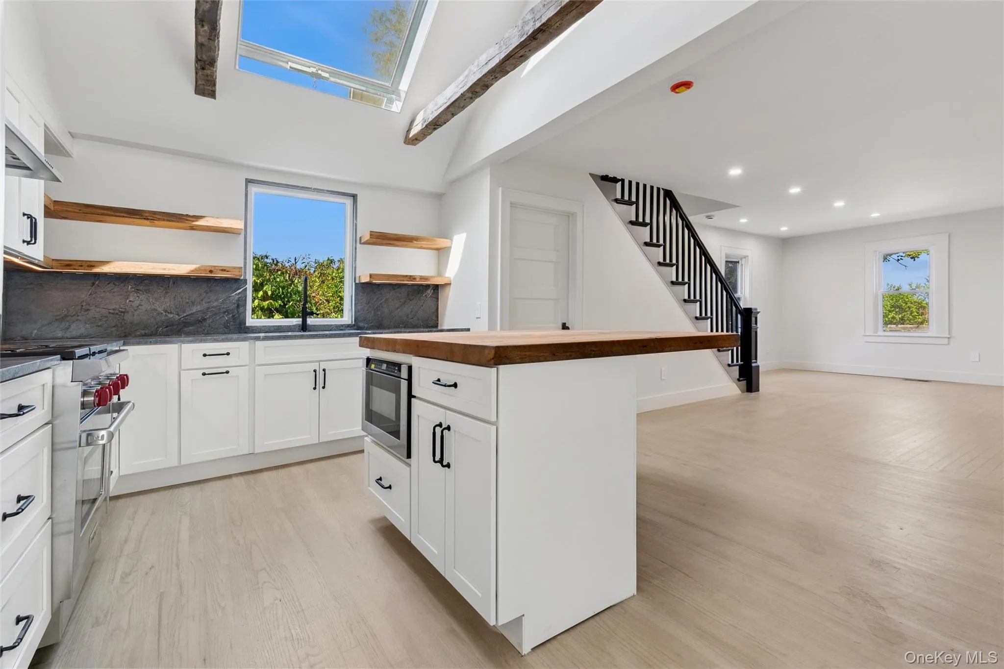 Kitchen featuring white cabinets, open shelves, decorative backsplash, butcher block countertops, and beamed ceiling Kitchen featuring white cabinets, open shelves, decorative backsplash, butcher block countertops, and beamed ceiling