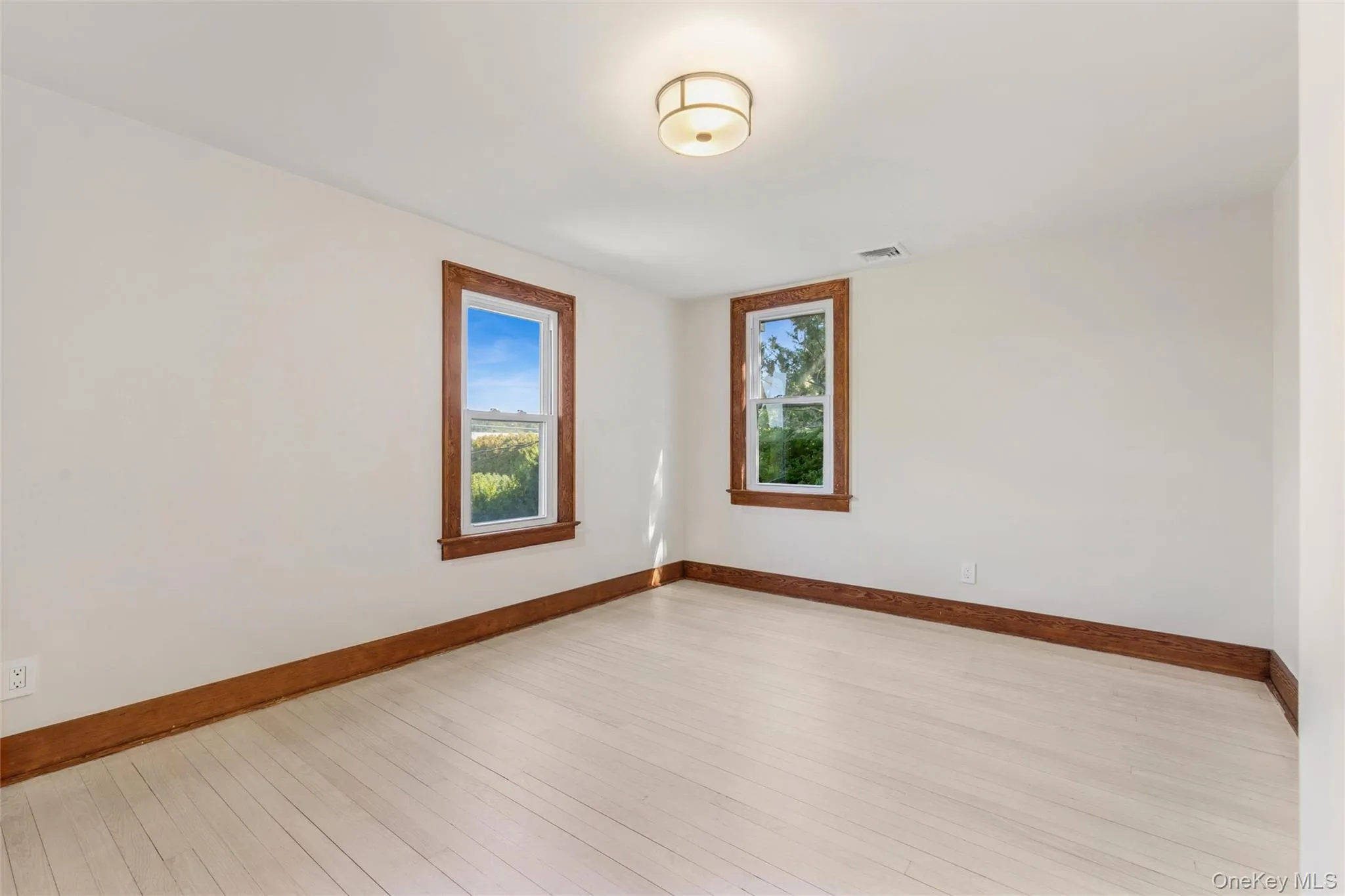 Empty room with baseboards and hardwood / wood-style floors Empty room with baseboards and hardwood / wood-style floors