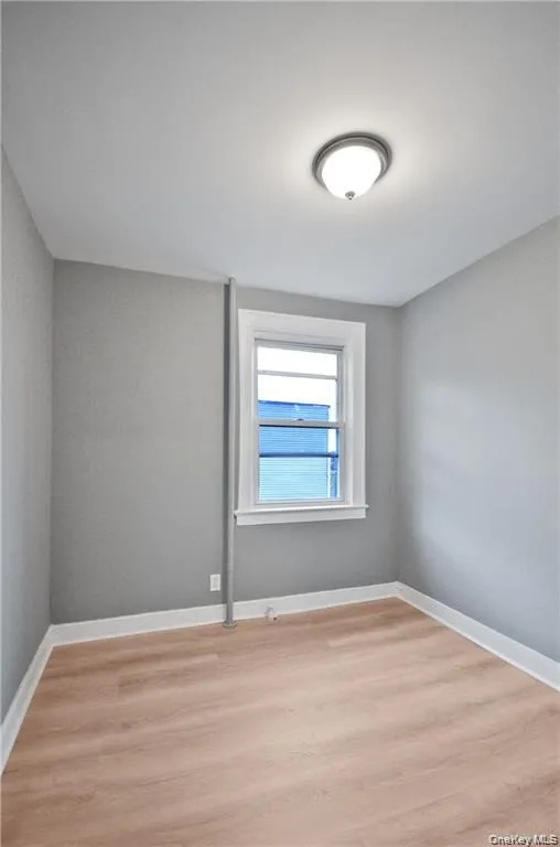 Unfurnished room with light wood-style floors and baseboards Unfurnished room with light wood-style floors and baseboards