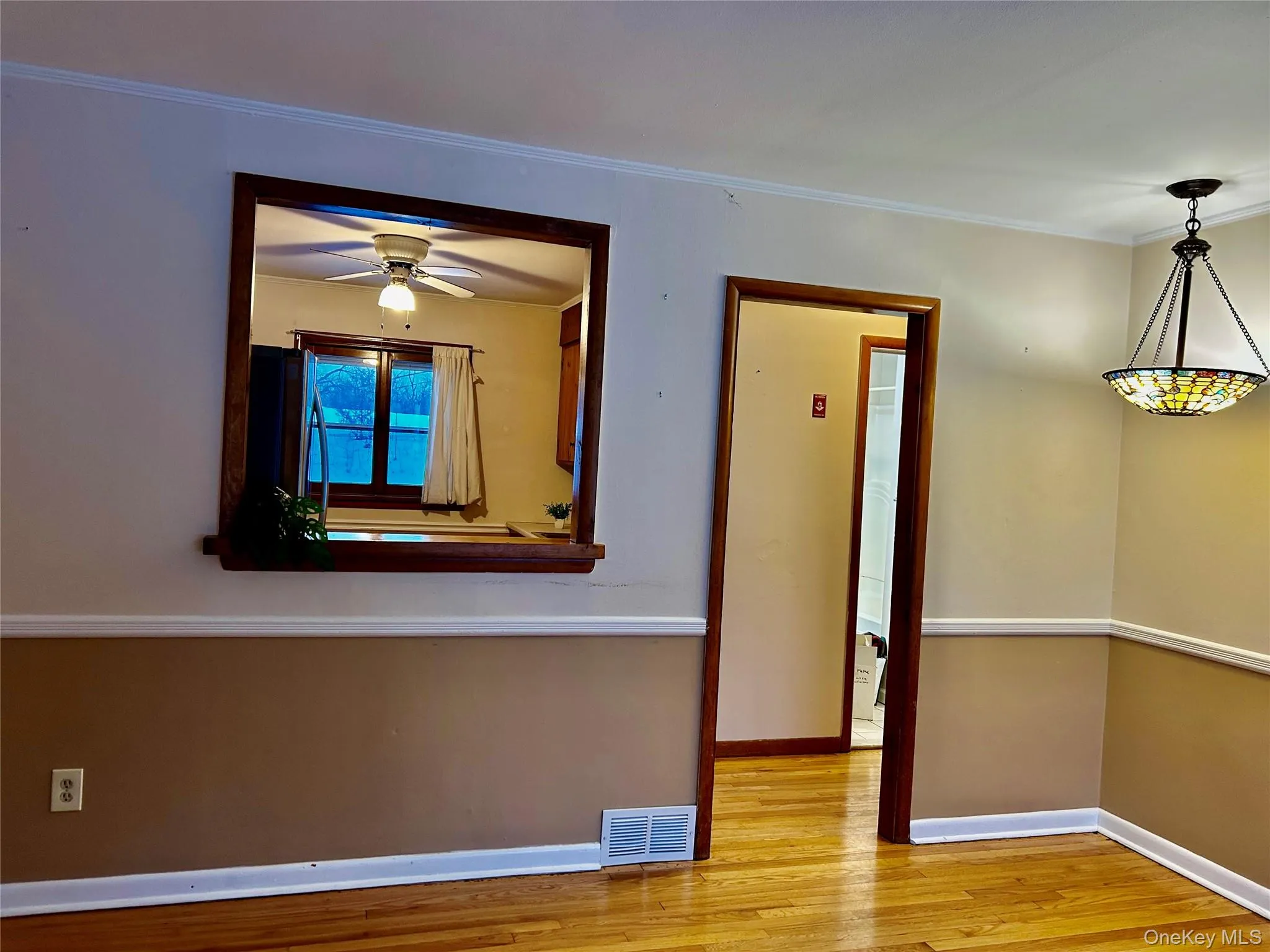Unfurnished room featuring light wood-style floors, crown molding, and a ceiling fan Unfurnished room featuring light wood-style floors, crown molding, and a ceiling fan