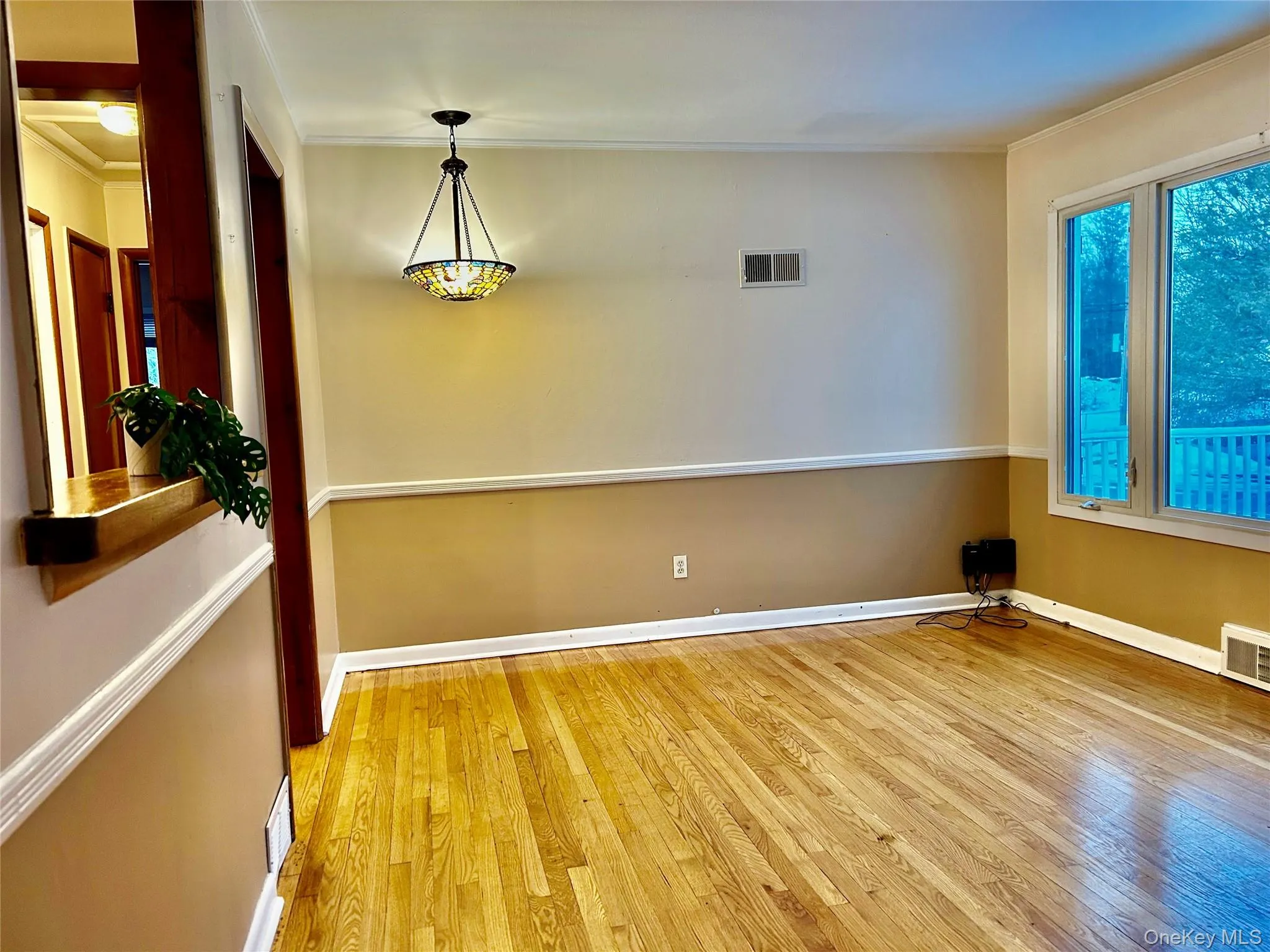 Empty room featuring ornamental molding and light wood-style floors Empty room featuring ornamental molding and light wood-style floors