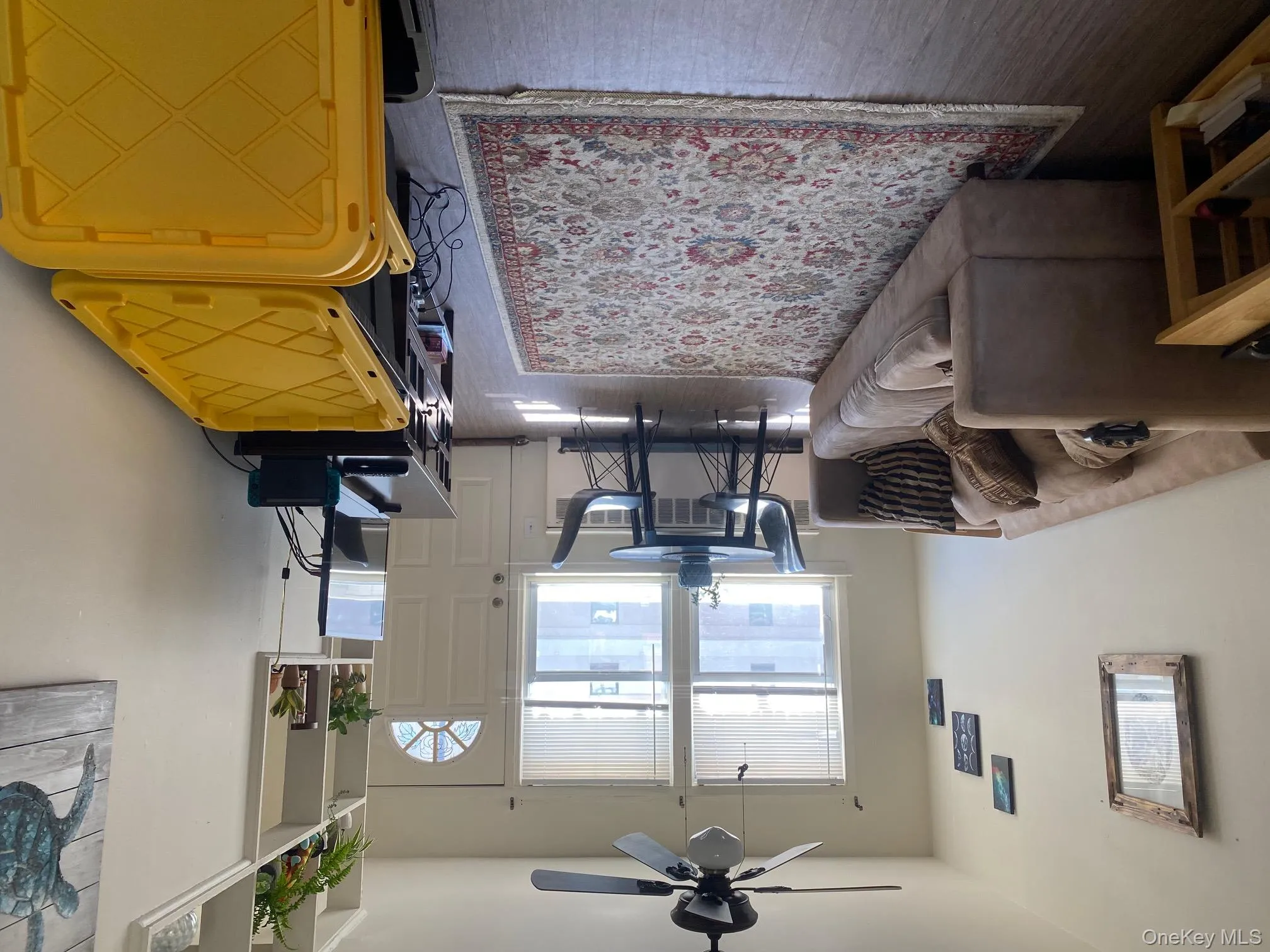 Living area featuring radiator, wood finished floors, and ceiling fan Living area featuring radiator, wood finished floors, and ceiling fan