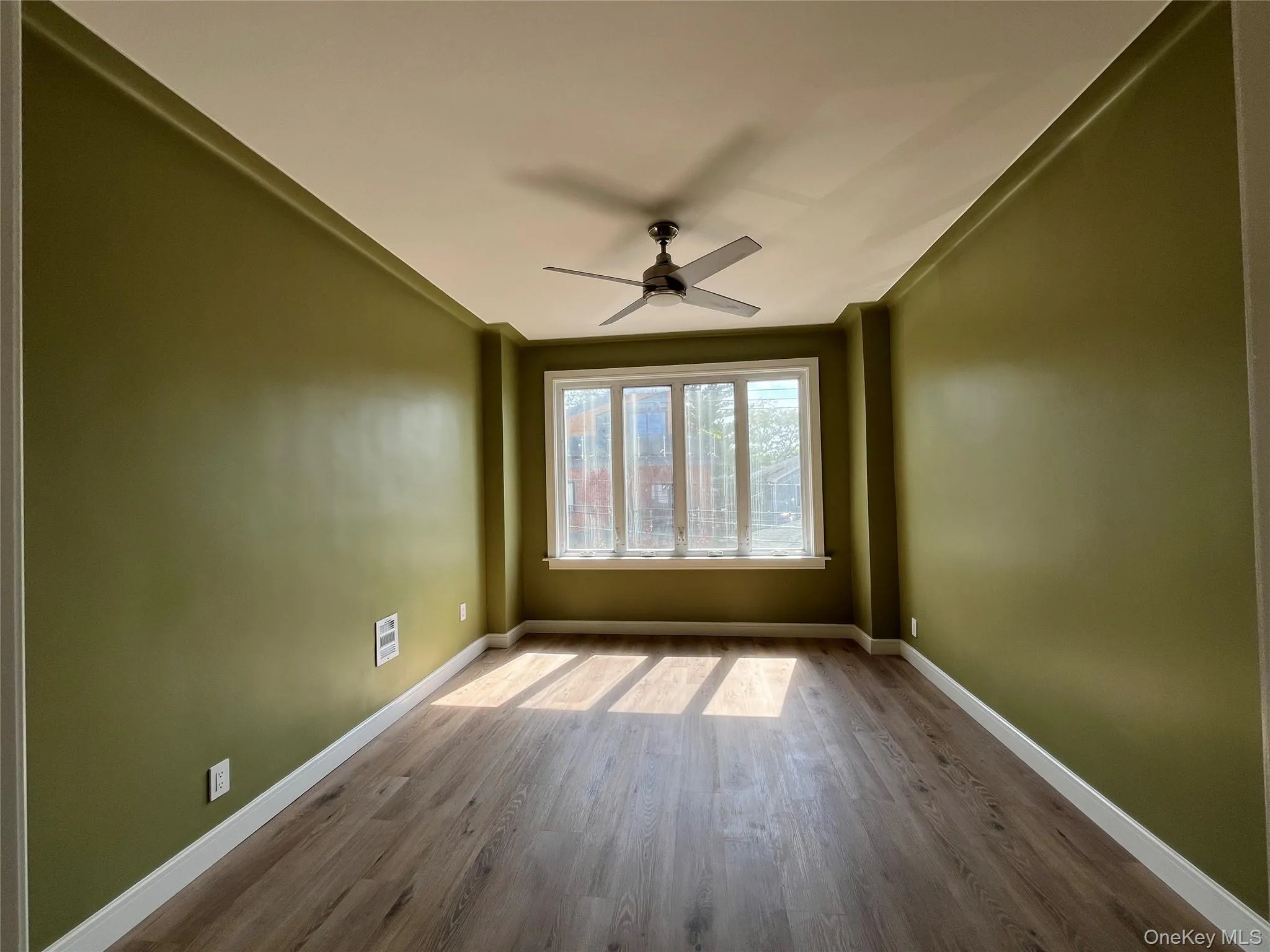 Empty room with wood finished floors and ceiling fan Empty room with wood finished floors and ceiling fan