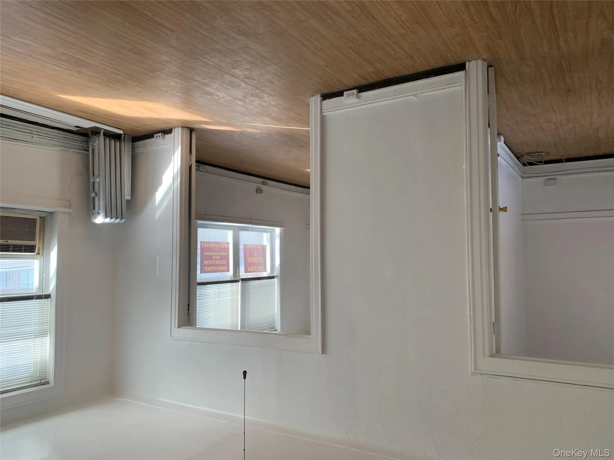 Spare room featuring light wood finished floors, radiator heating unit, a baseboard radiator, and cooling unit Spare room featuring light wood finished floors, radiator heating unit, a baseboard radiator, and cooling unit