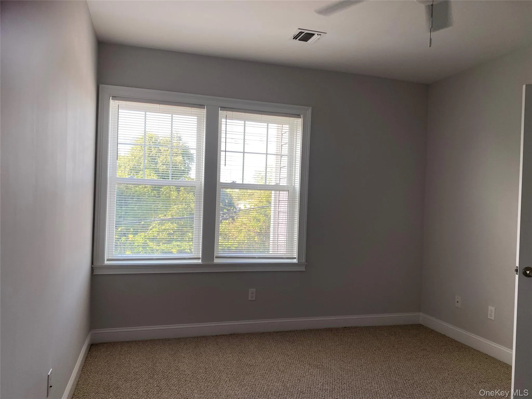 Spare room featuring light carpet and a ceiling fan Spare room featuring light carpet and a ceiling fan