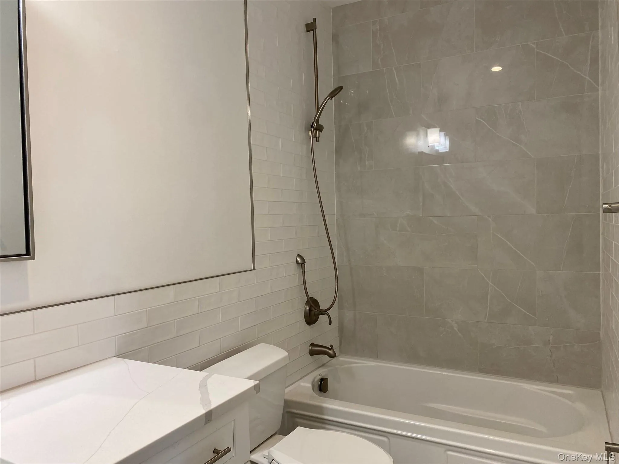 Full bath with bathtub / shower combination, vanity, and tile walls Full bath with bathtub / shower combination, vanity, and tile walls