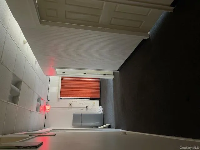 Hallway with dark carpet and a drop ceiling Hallway with dark carpet and a drop ceiling