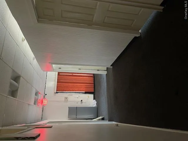 Hallway with dark carpet and a drop ceiling Hallway with dark carpet and a drop ceiling