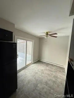 Unfurnished dining area with a ceiling fan and baseboard heating Unfurnished dining area with a ceiling fan and baseboard heating