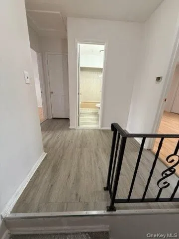 Corridor featuring light wood finished floors and baseboards Corridor featuring light wood finished floors and baseboards