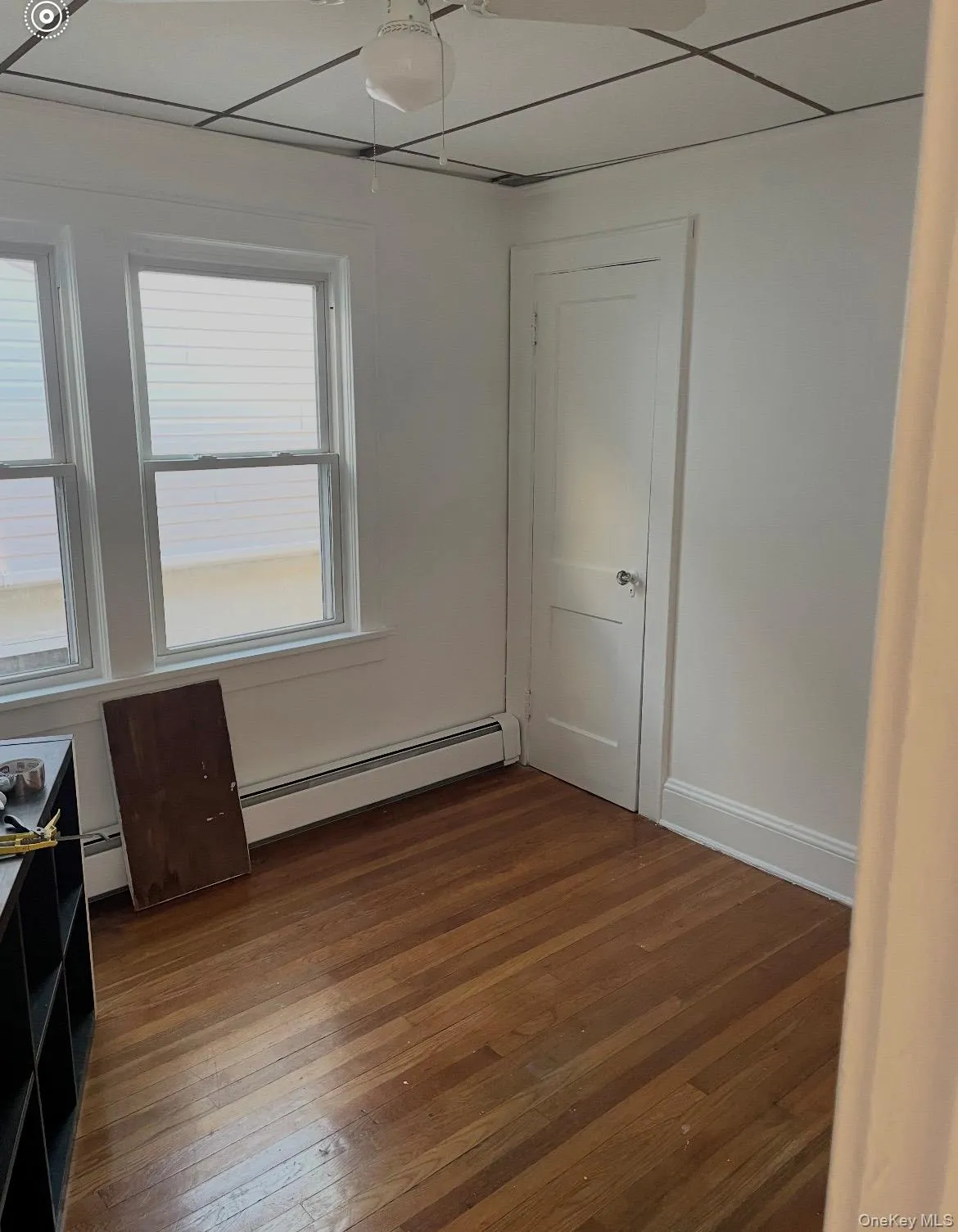 Spare room with dark wood-style flooring, a baseboard heating unit, and baseboard heating Spare room with dark wood-style flooring, a baseboard heating unit, and baseboard heating