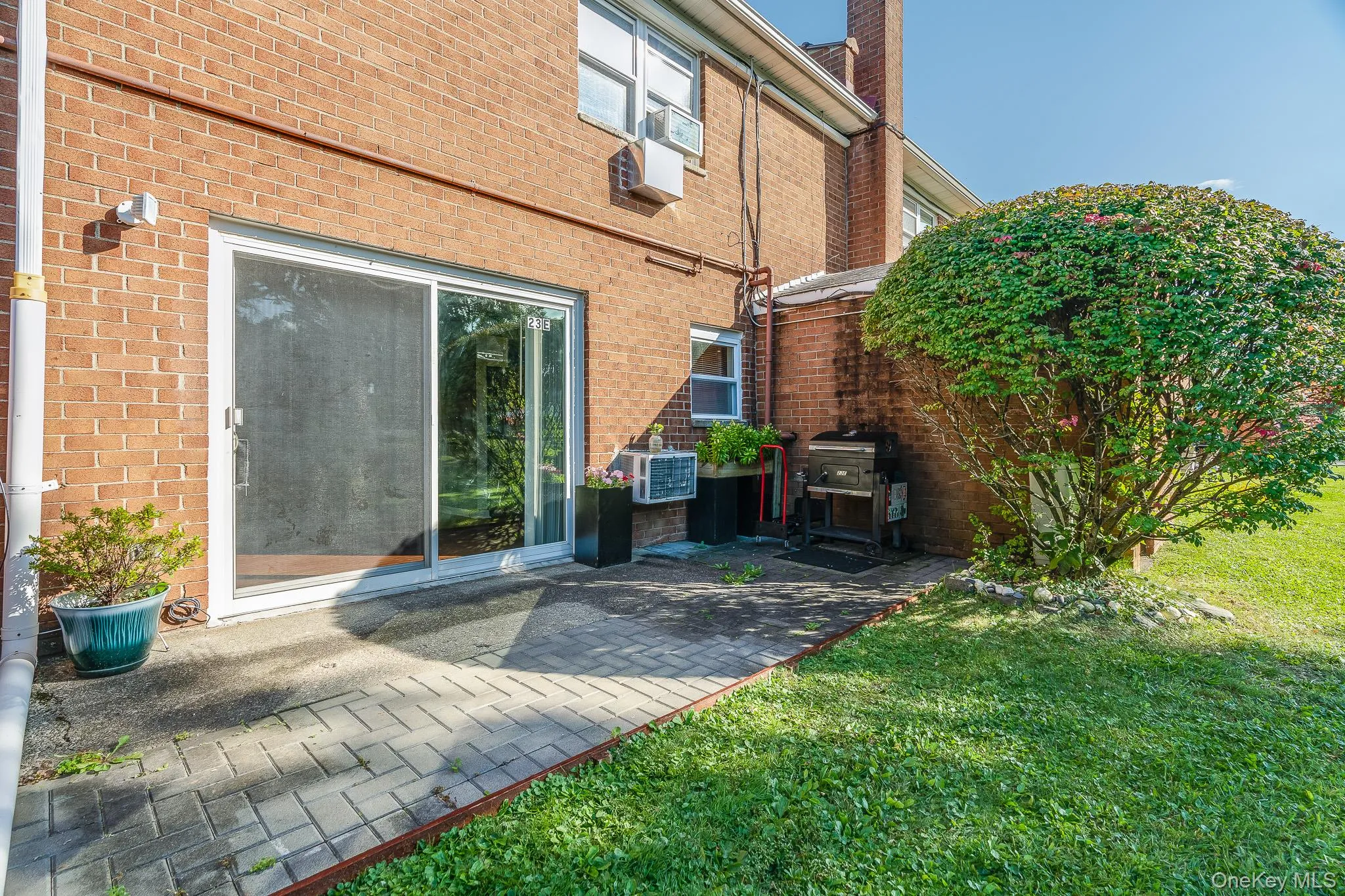 Back of house featuring brick siding, a yard, a patio, and a chimney Back of house featuring brick siding, a yard, a patio, and a chimney