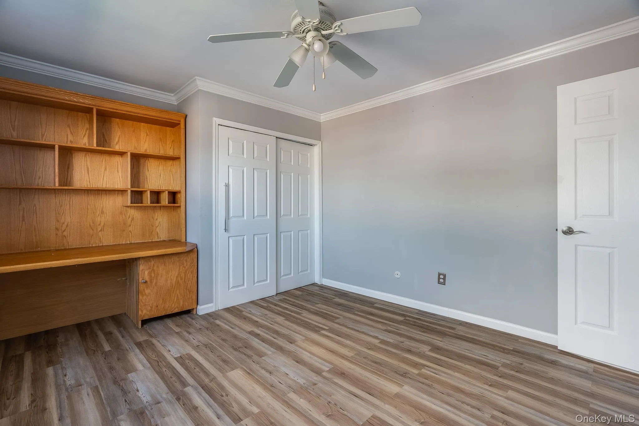 Unfurnished office with crown molding, dark wood-type flooring, and ceiling fan Unfurnished office with crown molding, dark wood-type flooring, and ceiling fan
