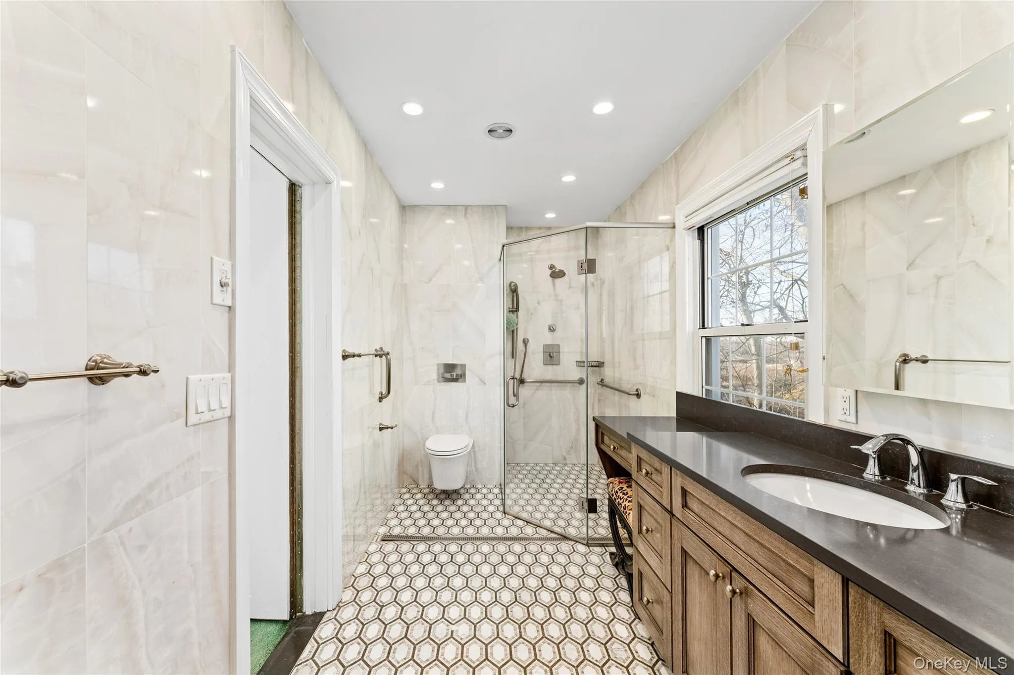 Full bathroom featuring tile walls, vanity, a shower stall, recessed lighting, and light tile patterned floors Full bathroom featuring tile walls, vanity, a shower stall, recessed lighting, and light tile patterned floors