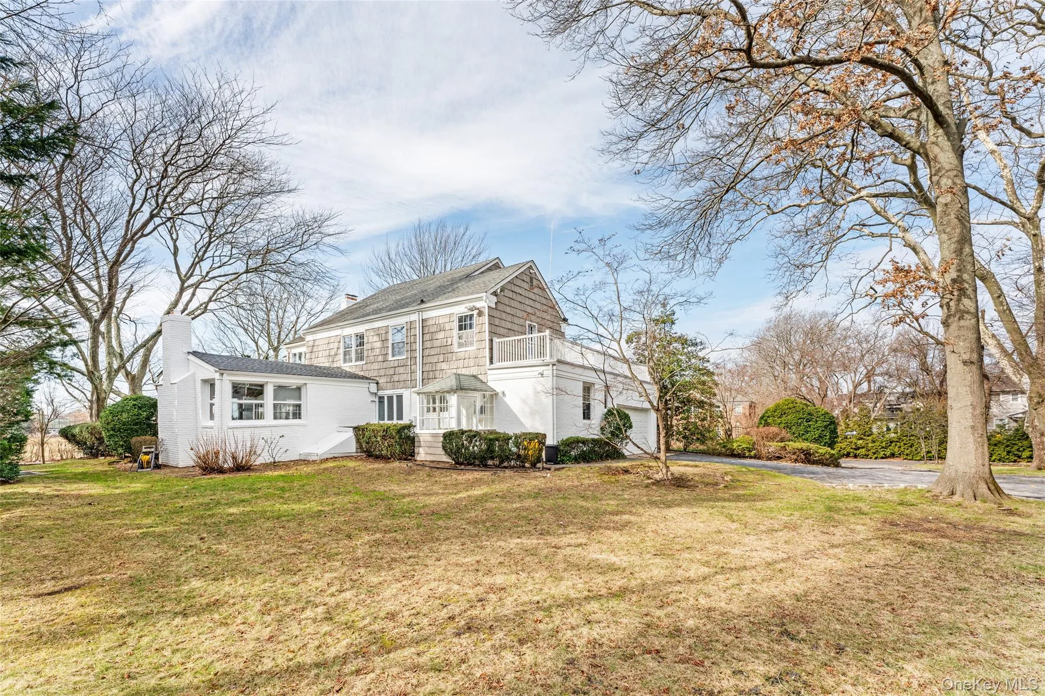 View of front facade with driveway, a front lawn, a chimney, and a garage View of front facade with driveway, a front lawn, a chimney, and a garage