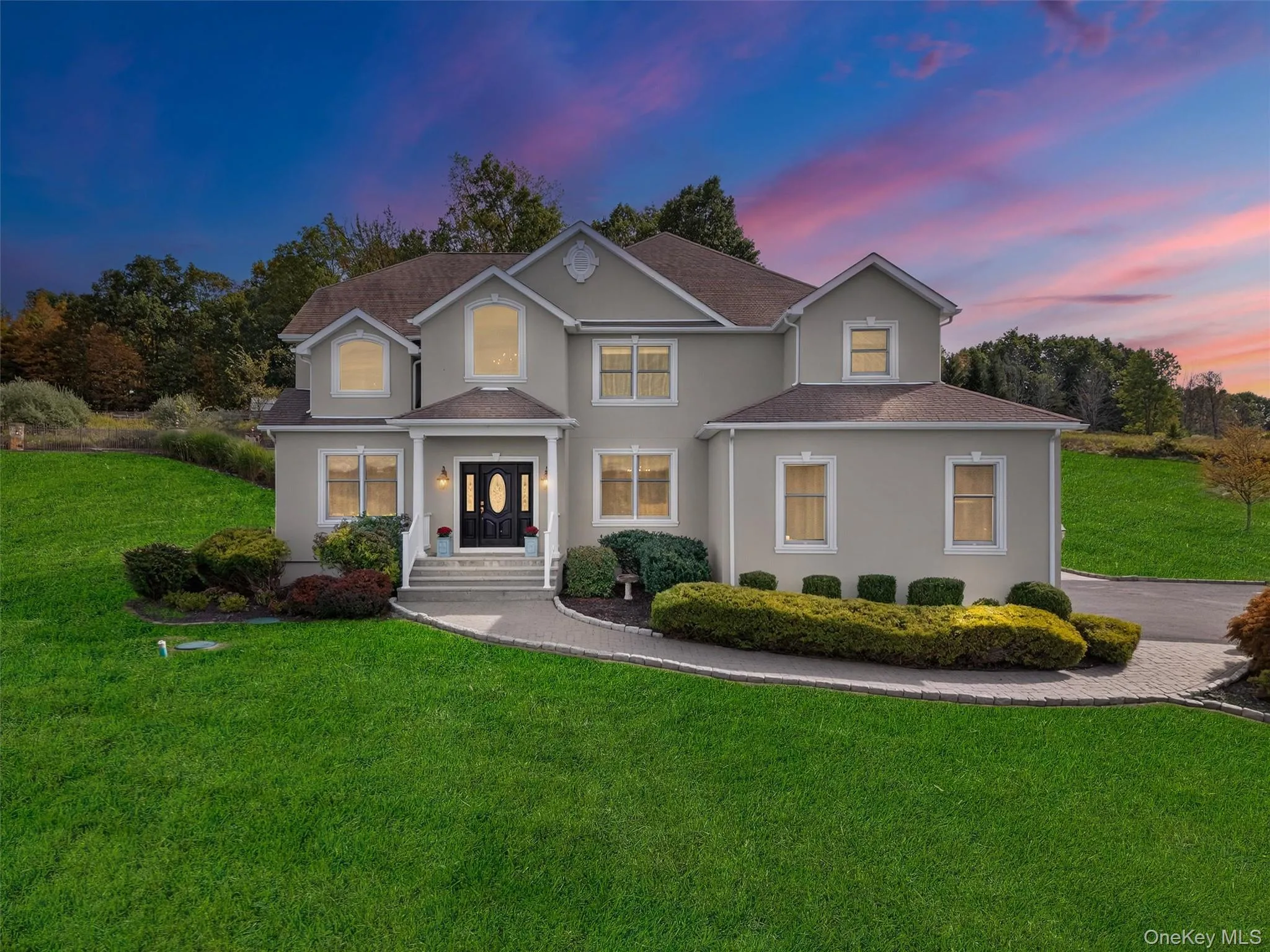Traditional home with a front yard, stucco siding, and a shingled roof Traditional home with a front yard, stucco siding, and a shingled roof