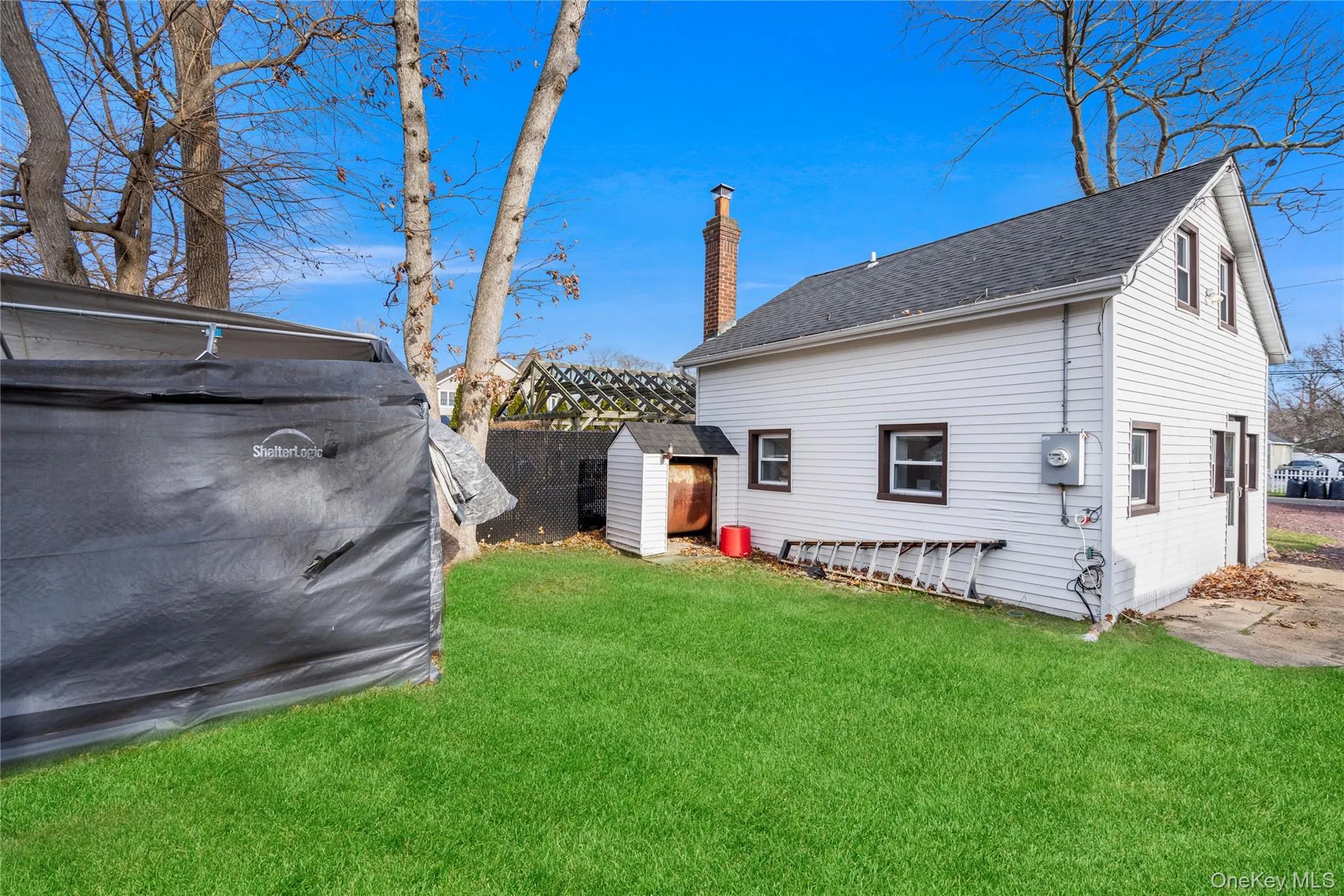 View of side of home featuring a chimney and roof with shingles View of side of home featuring a chimney and roof with shingles