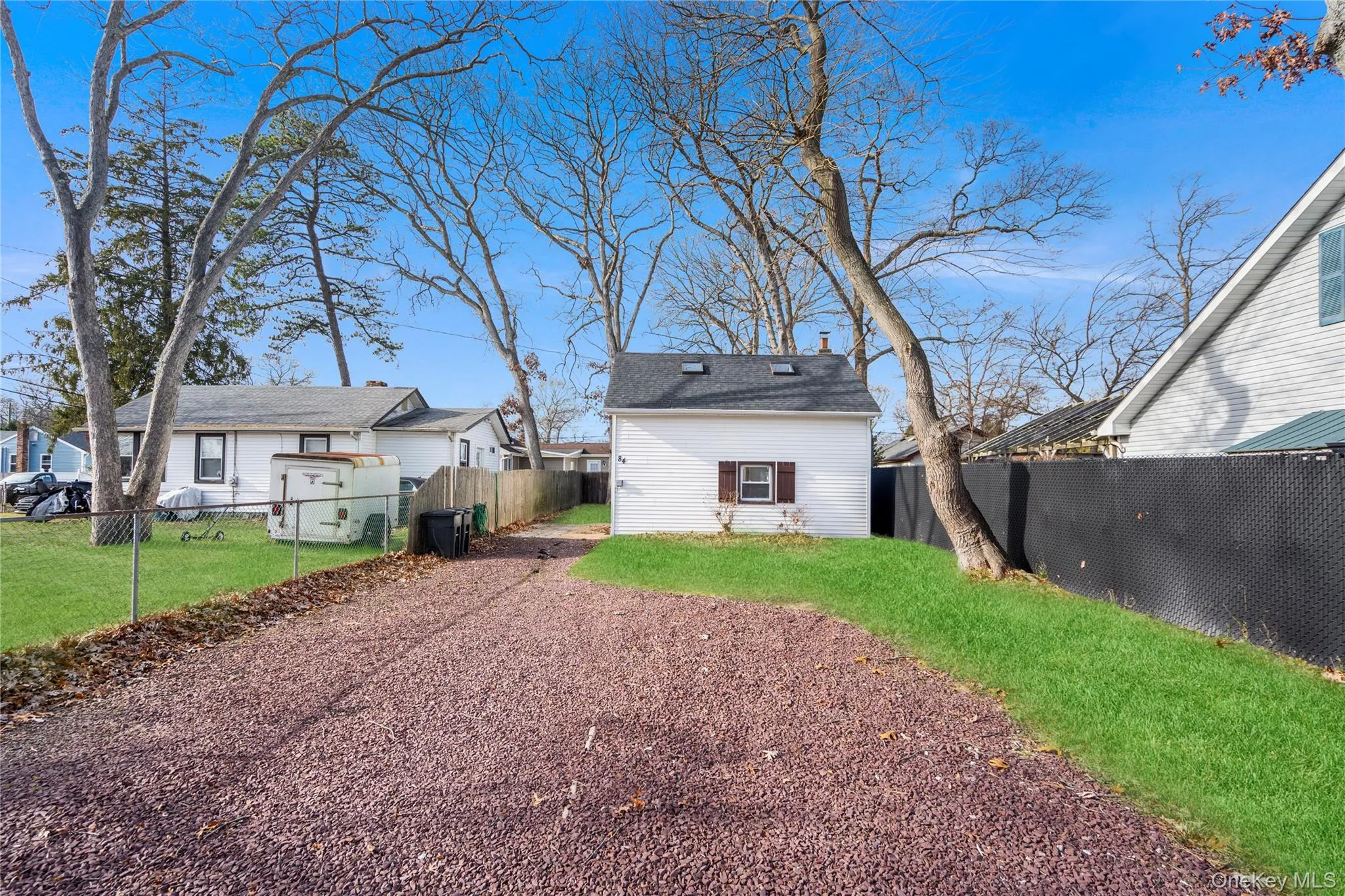 Back of house featuring a fenced backyard and roof with shingles Back of house featuring a fenced backyard and roof with shingles
