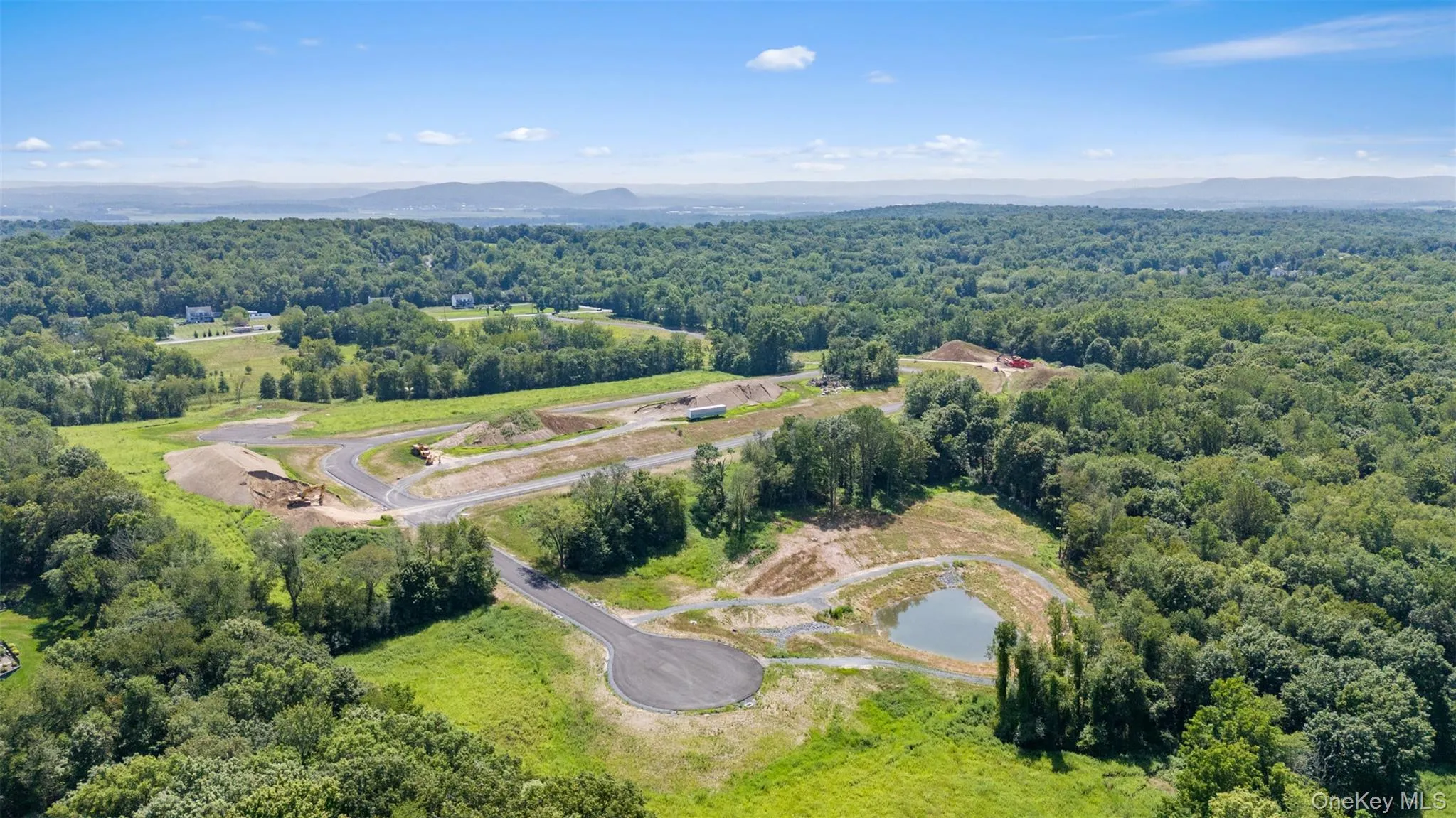 Bird's eye view of a heavily wooded area and a water and mountain view Bird's eye view of a heavily wooded area and a water and mountain view