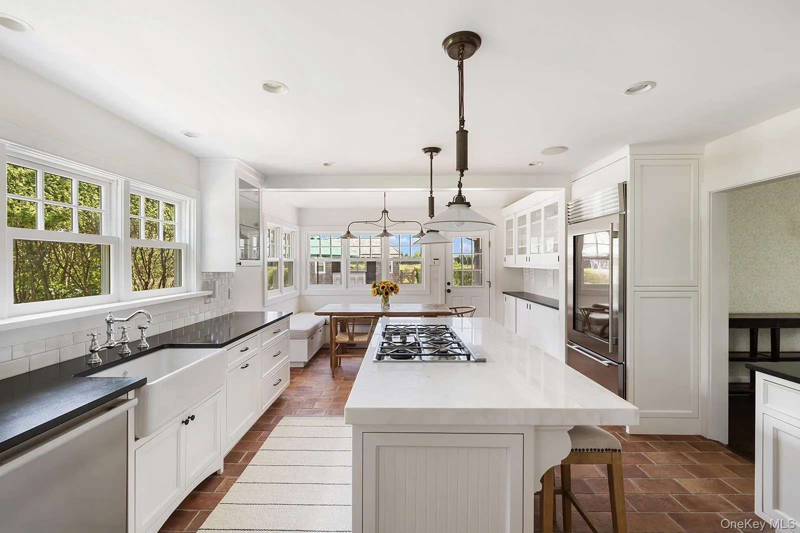 Kitchen featuring white cabinets, glass insert cabinets, a kitchen breakfast bar, and recessed lighting Kitchen featuring white cabinets, glass insert cabinets, a kitchen breakfast bar, and recessed lighting