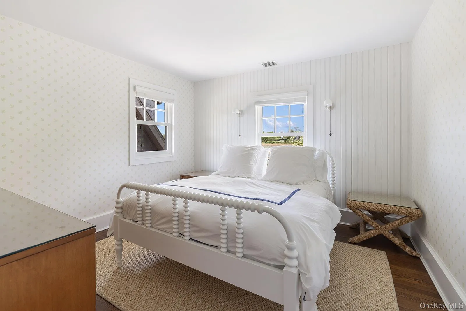 Bedroom with dark wood-style floors and wallpapered walls Bedroom with dark wood-style floors and wallpapered walls
