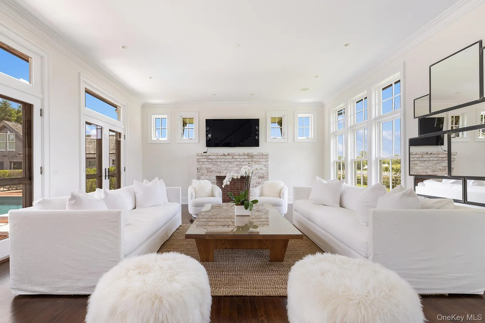Living room featuring crown molding, wood-type flooring, and a fireplace Living room featuring crown molding, wood-type flooring, and a fireplace