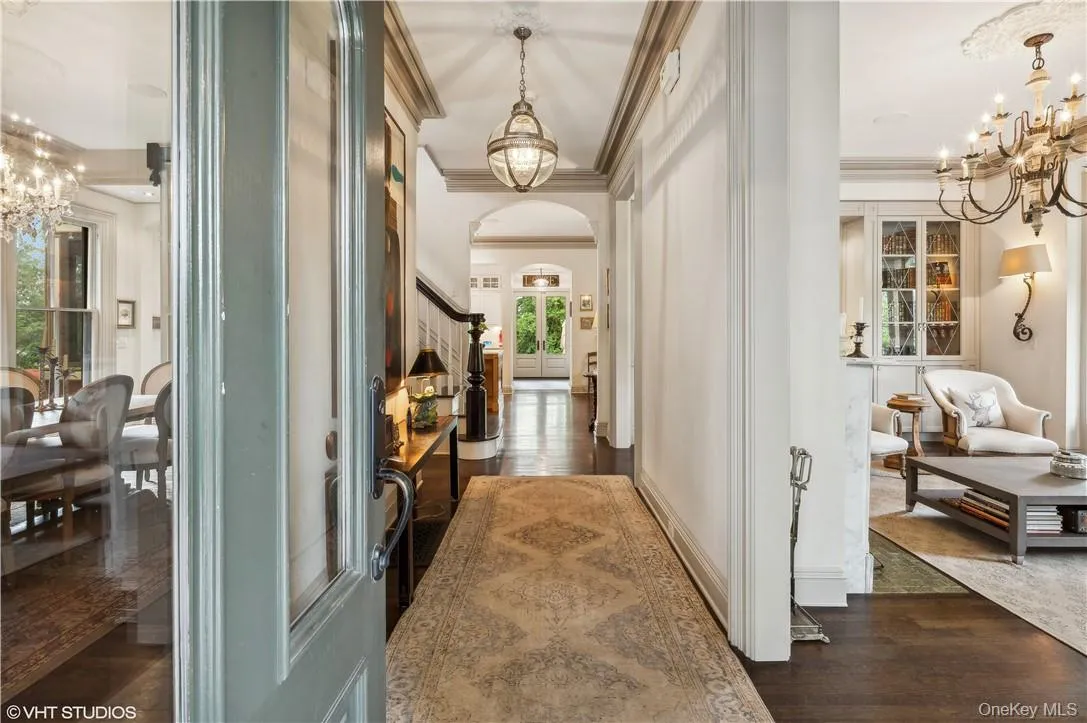 Hall featuring crown molding, dark hardwood / wood-style floors, and a chandelier Hall featuring crown molding, dark hardwood / wood-style floors, and a chandelier