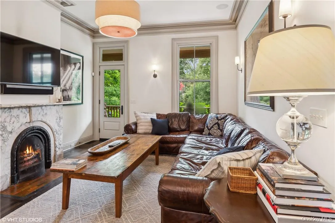 Living room with wood-type flooring, a wealth of natural light, and crown molding Living room with wood-type flooring, a wealth of natural light, and crown molding