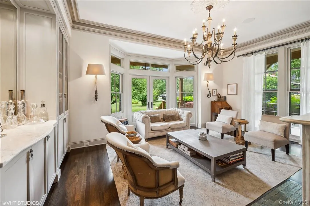 Living room featuring an inviting chandelier, dark hardwood / wood-style flooring, and ornamental molding Living room featuring an inviting chandelier, dark hardwood / wood-style flooring, and ornamental molding