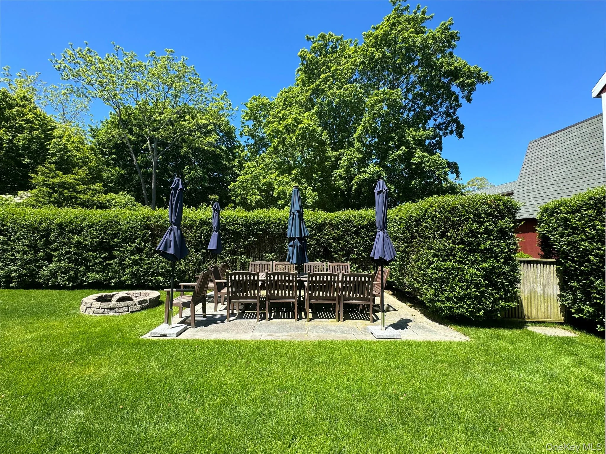 View of grassy yard featuring a fire pit and a patio View of grassy yard featuring a fire pit and a patio
