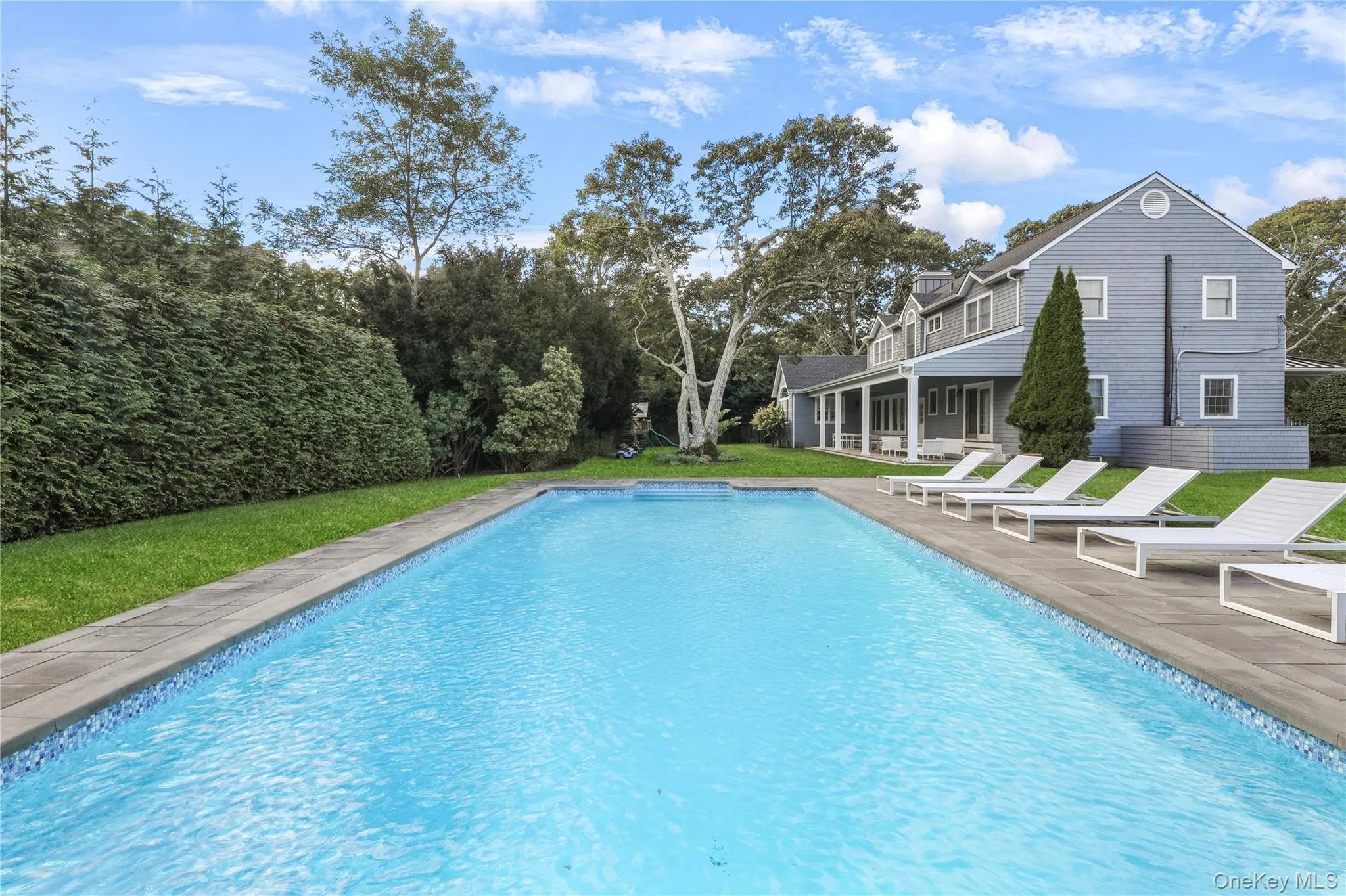Outdoor pool with a patio and a lawn Outdoor pool with a patio and a lawn