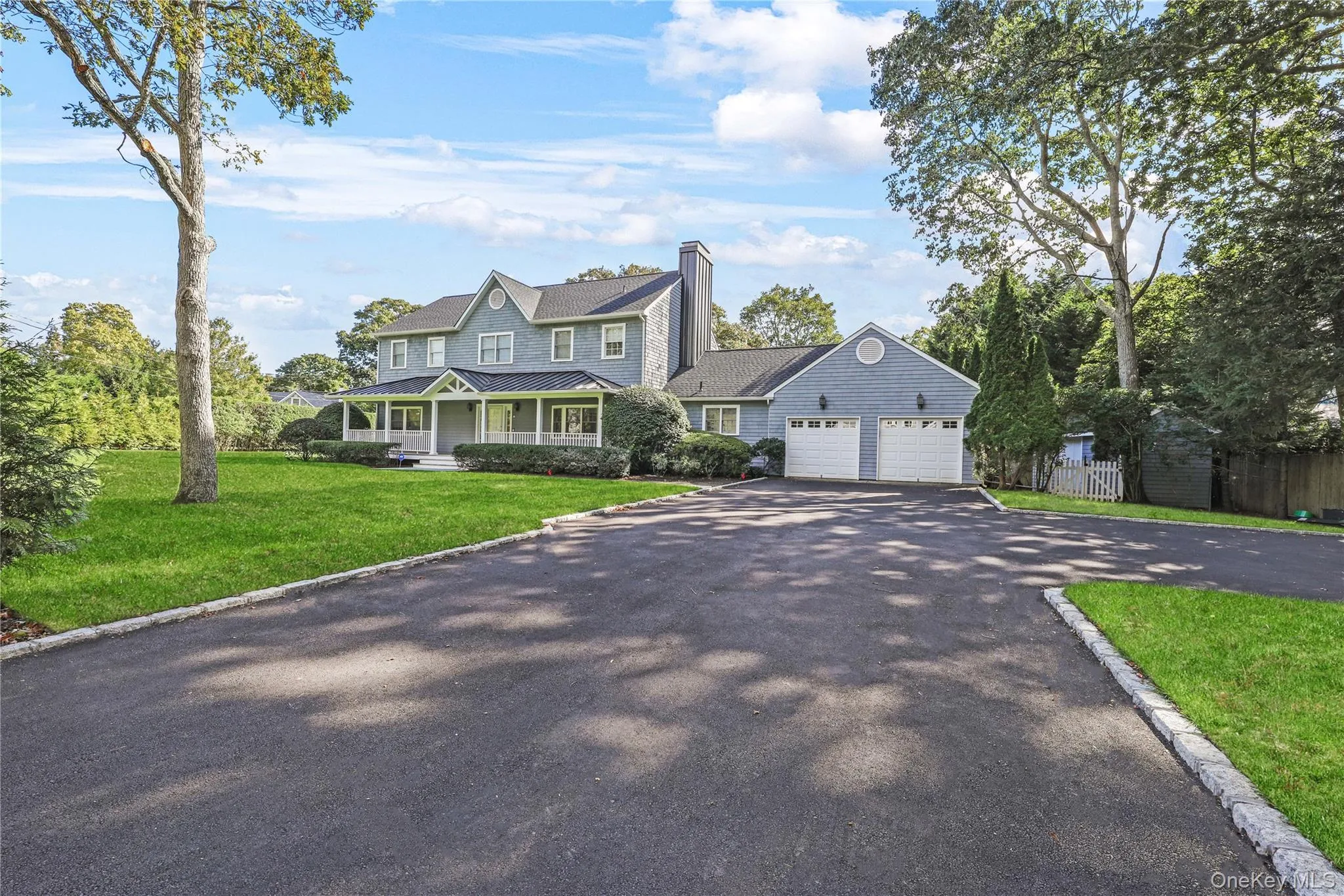 View of front of property featuring covered porch, driveway, a chimney, and a garage View of front of property featuring covered porch, driveway, a chimney, and a garage