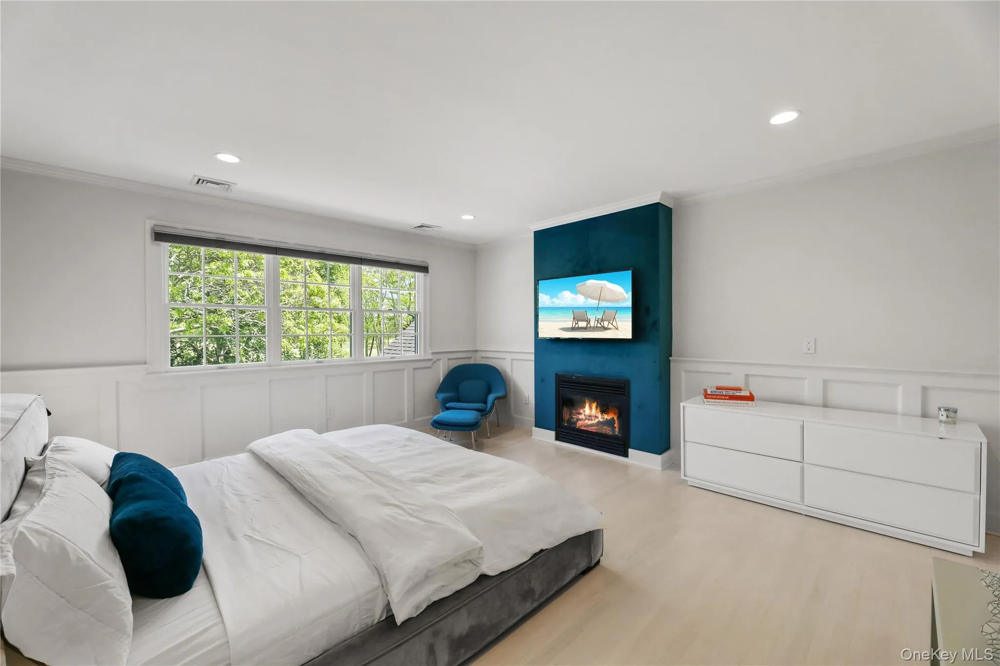 Bedroom with a decorative wall, ornamental molding, visible vents, and a wainscoted wall Bedroom with a decorative wall, ornamental molding, visible vents, and a wainscoted wall