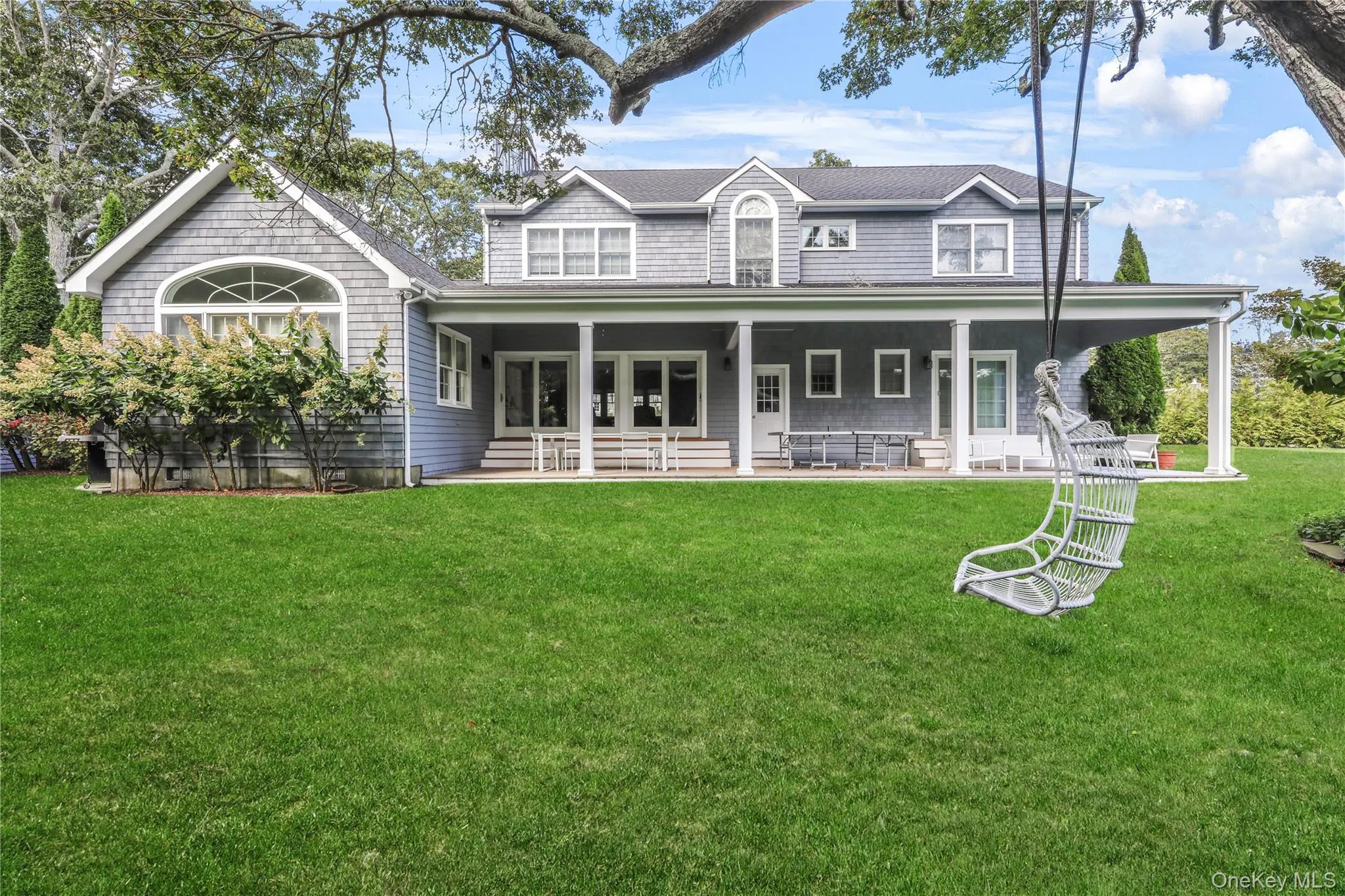 Rear view of house with covered porch and a yard Rear view of house with covered porch and a yard