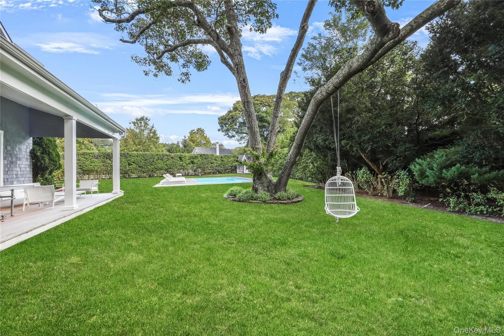 View of green lawn with a patio area View of green lawn with a patio area