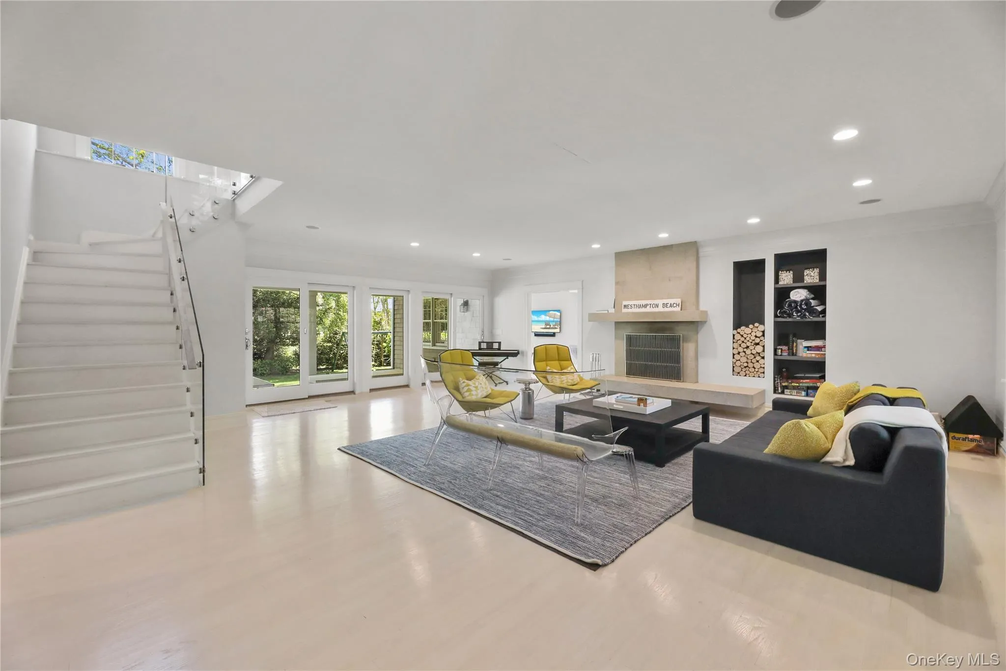 Living area featuring crown molding, a large fireplace, recessed lighting, stairway, and wood finished floors Living area featuring crown molding, a large fireplace, recessed lighting, stairway, and wood finished floors
