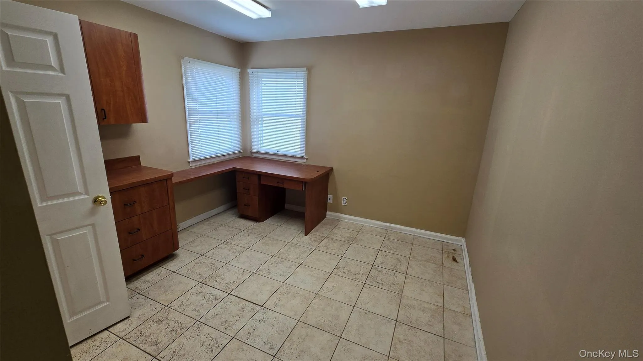 Unfurnished office featuring light tile patterned floors and built in study area Unfurnished office featuring light tile patterned floors and built in study area