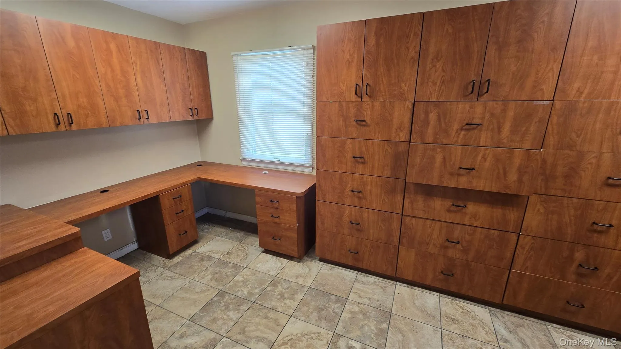 Unfurnished office featuring built in desk and baseboards Unfurnished office featuring built in desk and baseboards