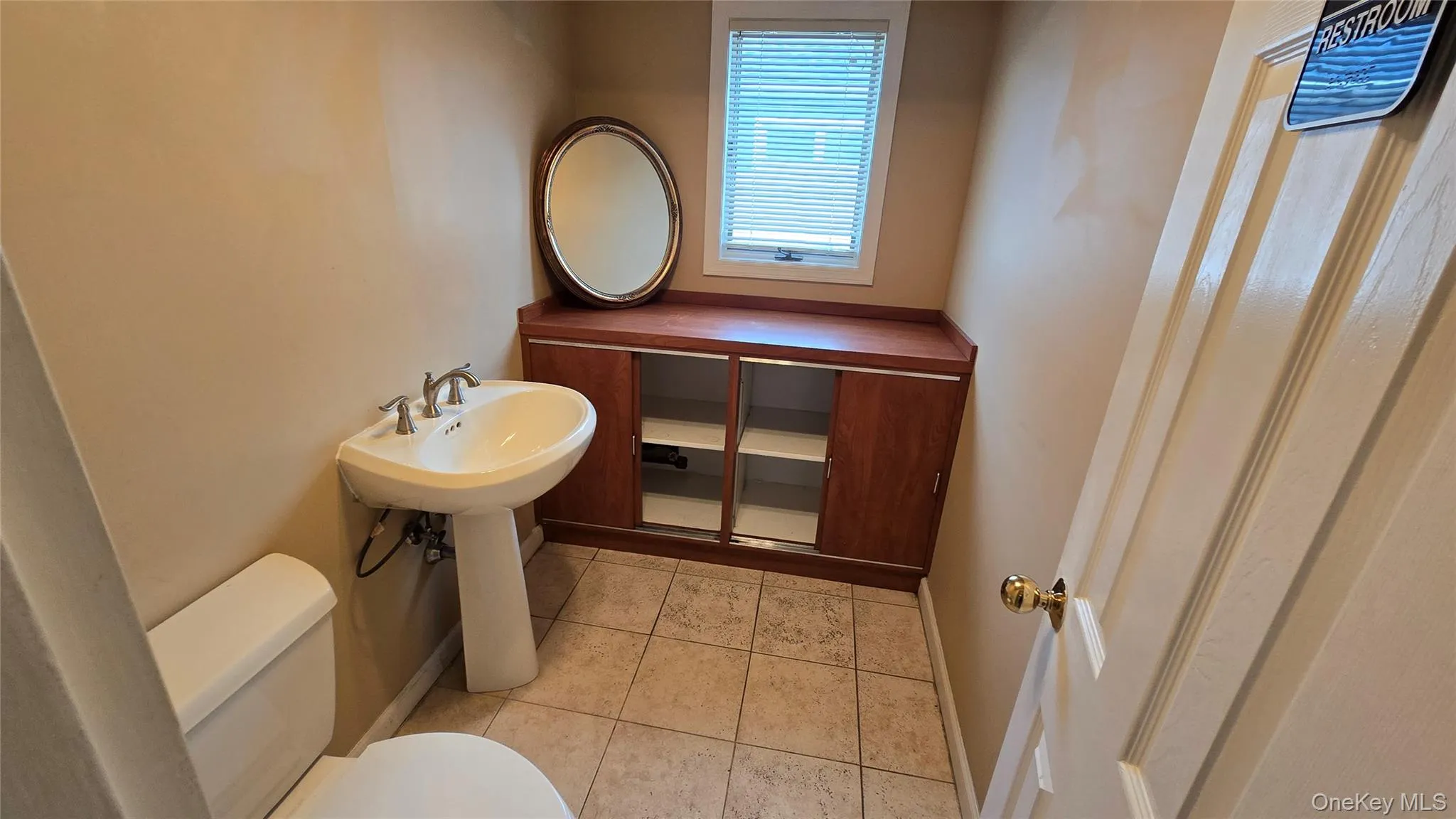 Half bathroom featuring toilet and light tile patterned flooring Half bathroom featuring toilet and light tile patterned flooring