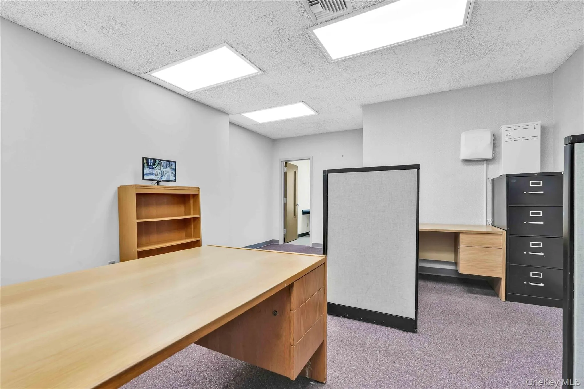 Unfurnished office featuring a textured ceiling and light colored carpet Unfurnished office featuring a textured ceiling and light colored carpet