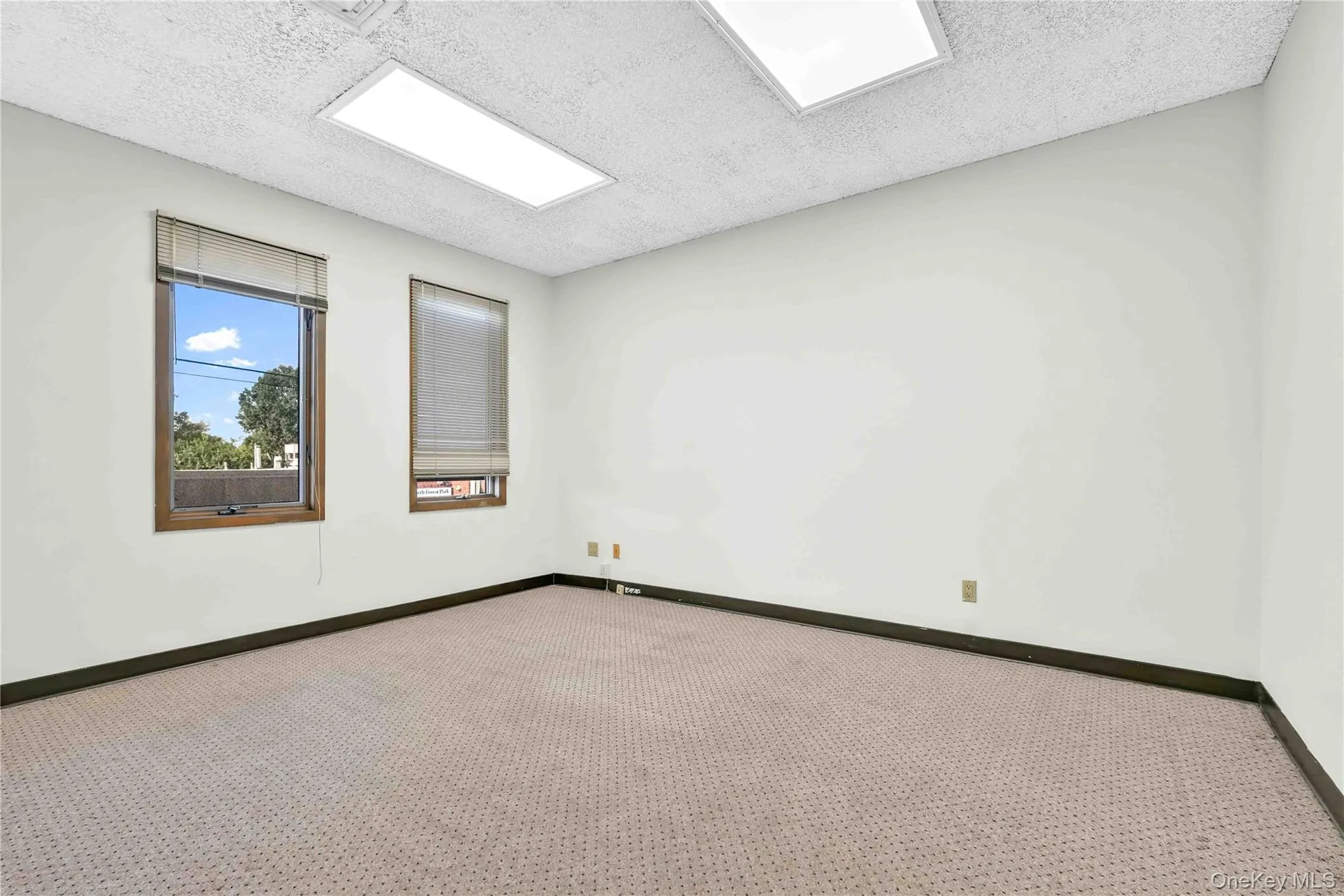 Unfurnished room with a textured ceiling and carpet flooring Unfurnished room with a textured ceiling and carpet flooring
