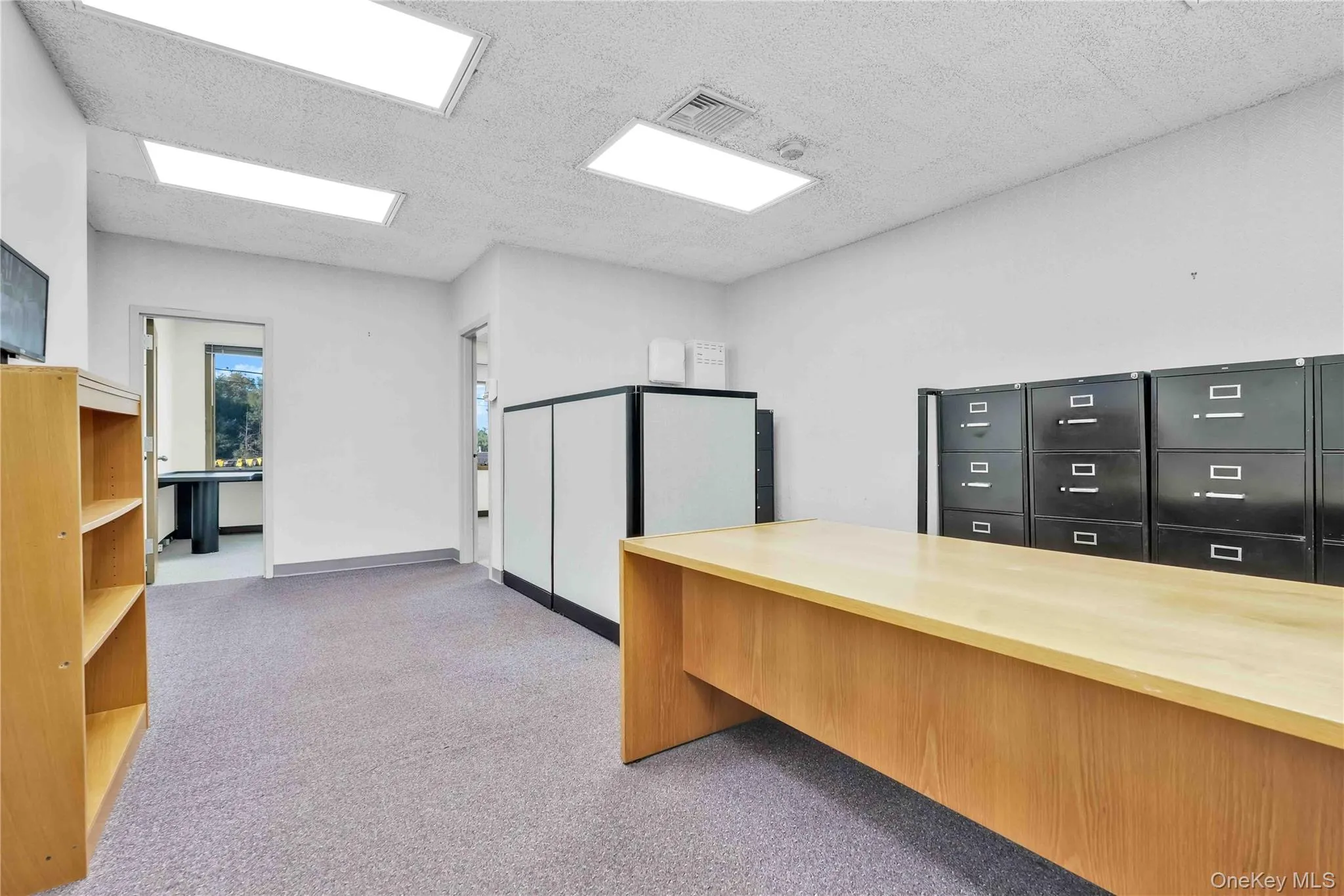 Office with light carpet and a textured ceiling Office with light carpet and a textured ceiling